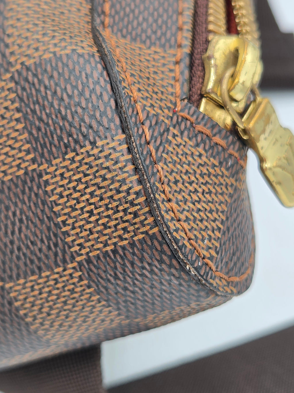 Close-up of a brown textured handbag with gold clasp