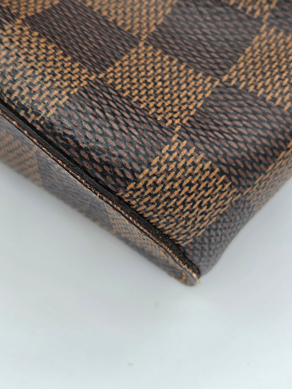 Close-up of a brown and black checkered patterned wallet on a white background