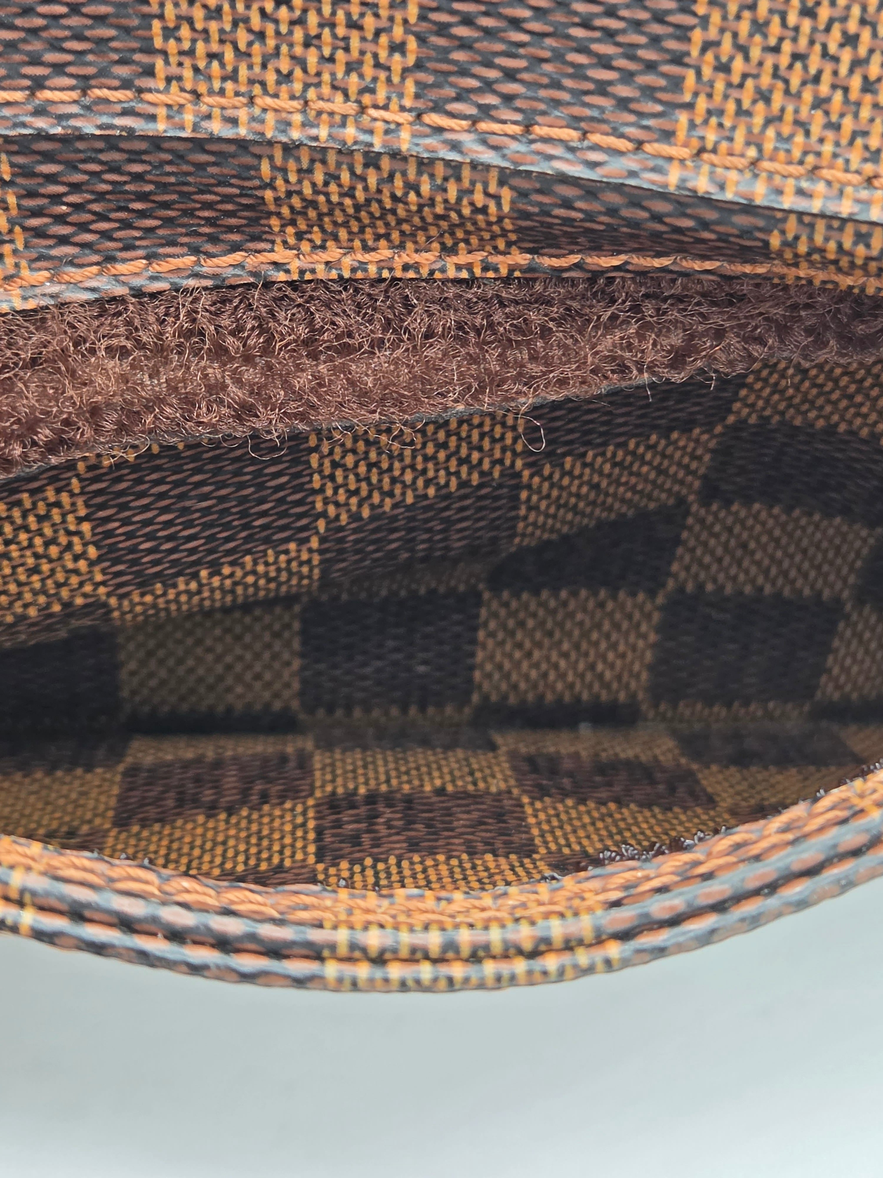 Close-up of a brown and black checkered fabric with a textured border.