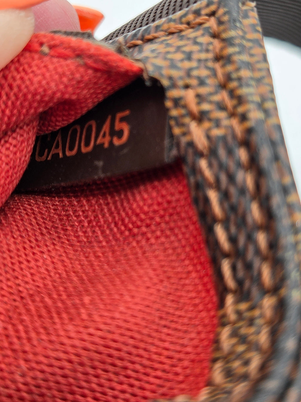 Close-up of a textured surface with a red fabric patch and a visible label.