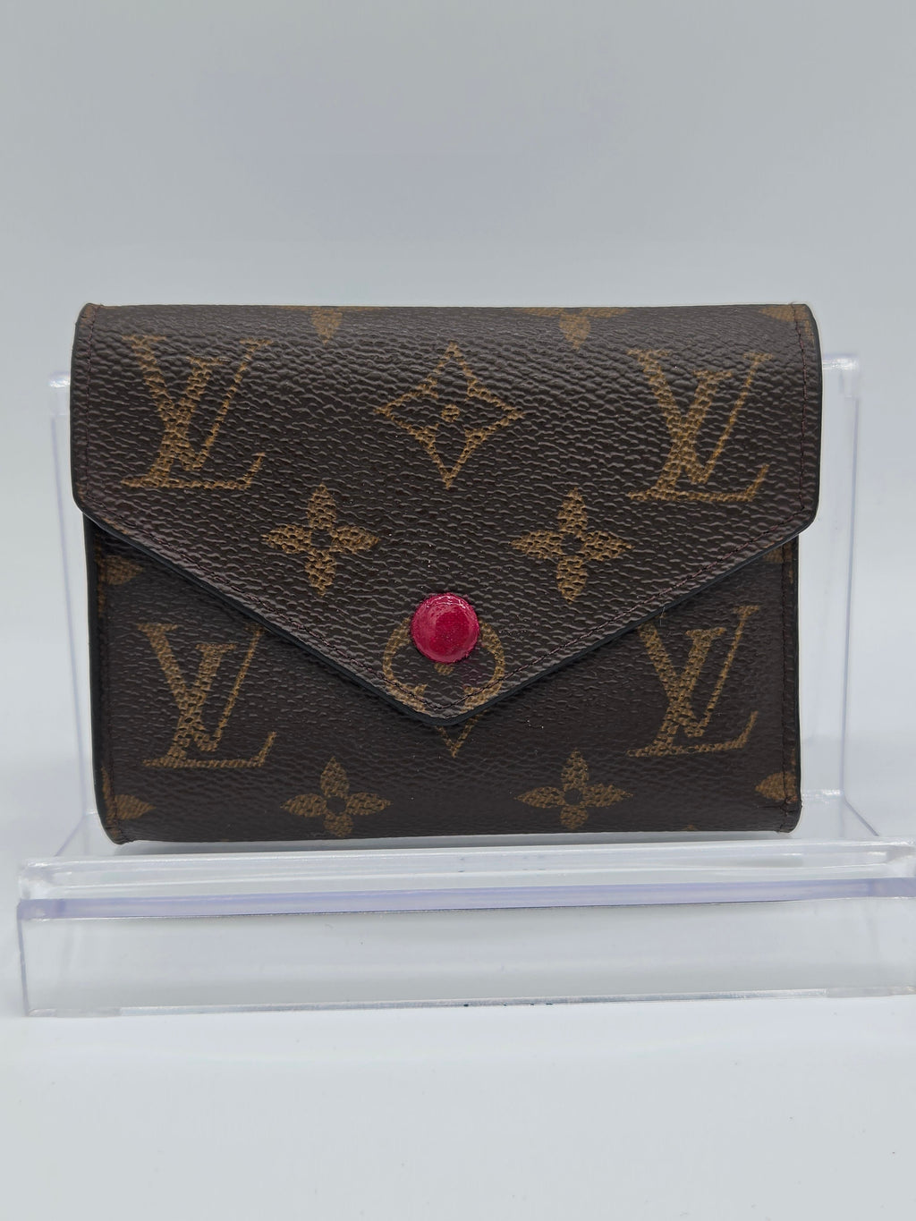 Louis Vuitton wallet with monogram pattern on a white background