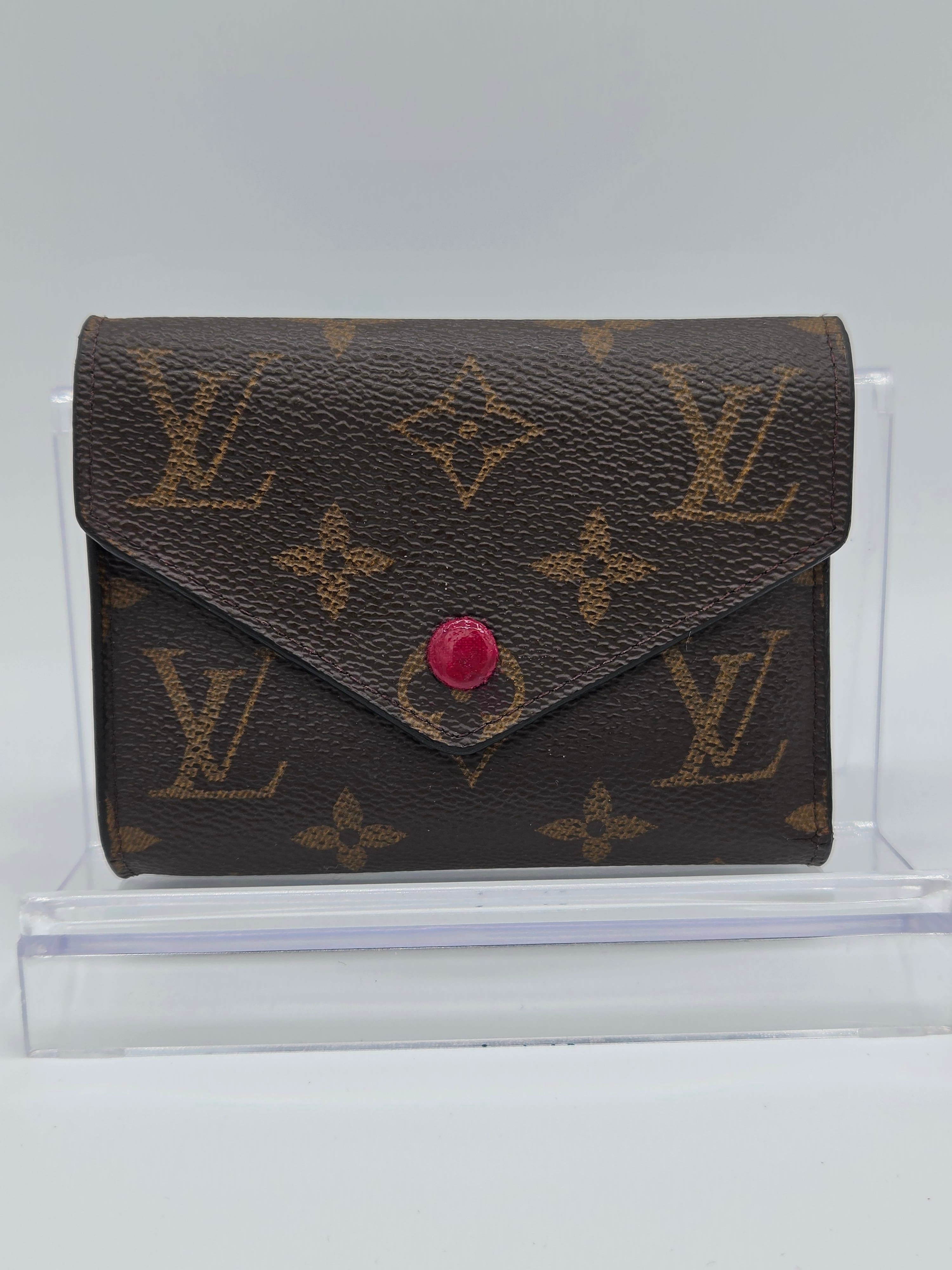 Louis Vuitton wallet with monogram pattern on a white background