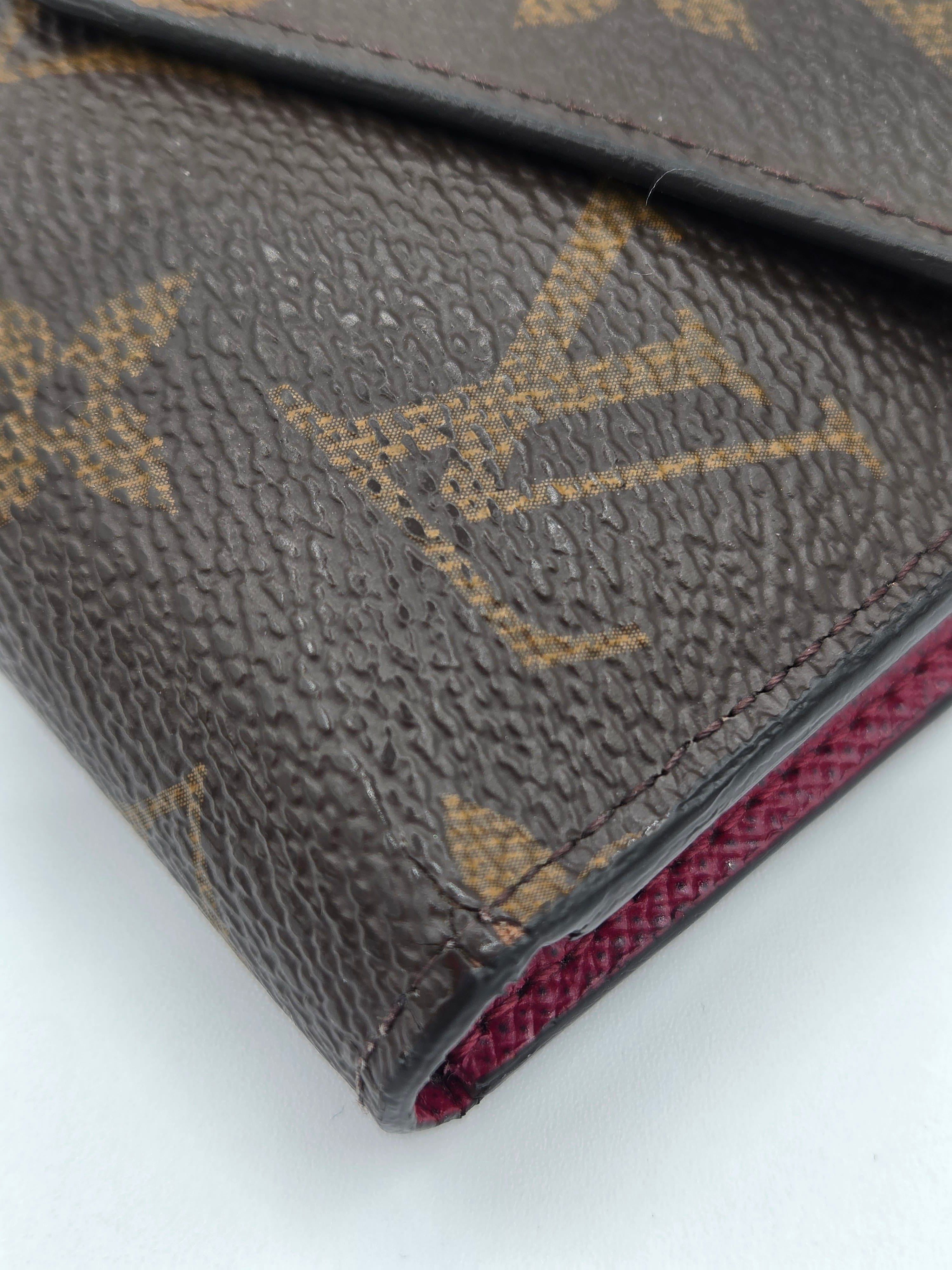 Close-up of a Louis Vuitton wallet with monogram pattern on a white background