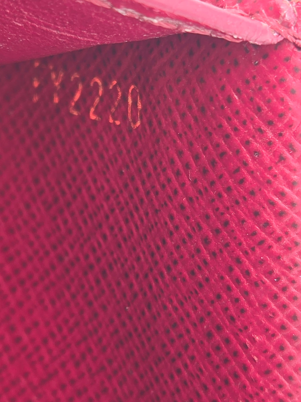 Close-up of a red textured surface with 'Dior' branding.