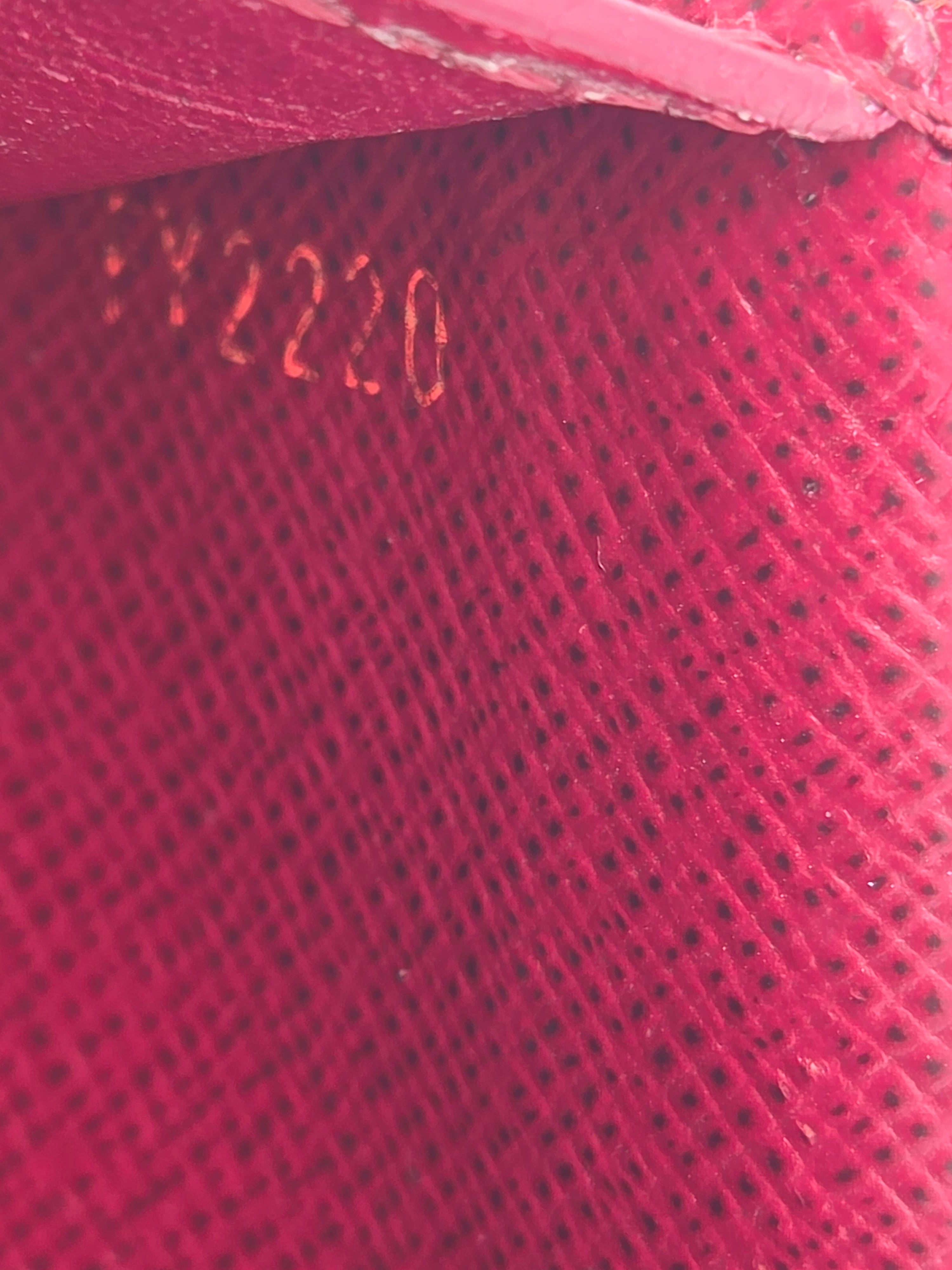 Close-up of a red textured surface with 'Dior' branding.