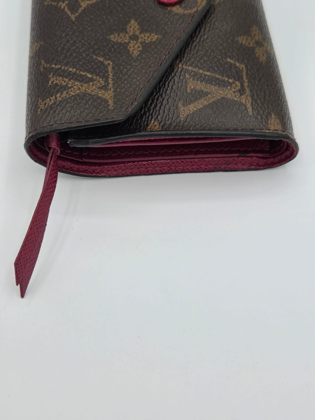 Close-up of a brown wallet with a pattern on a white background