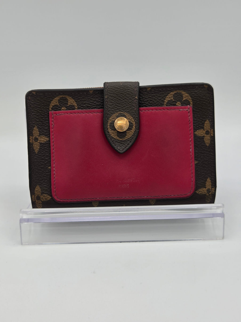 Designer wallet with red interior and brown exterior pattern on a white background