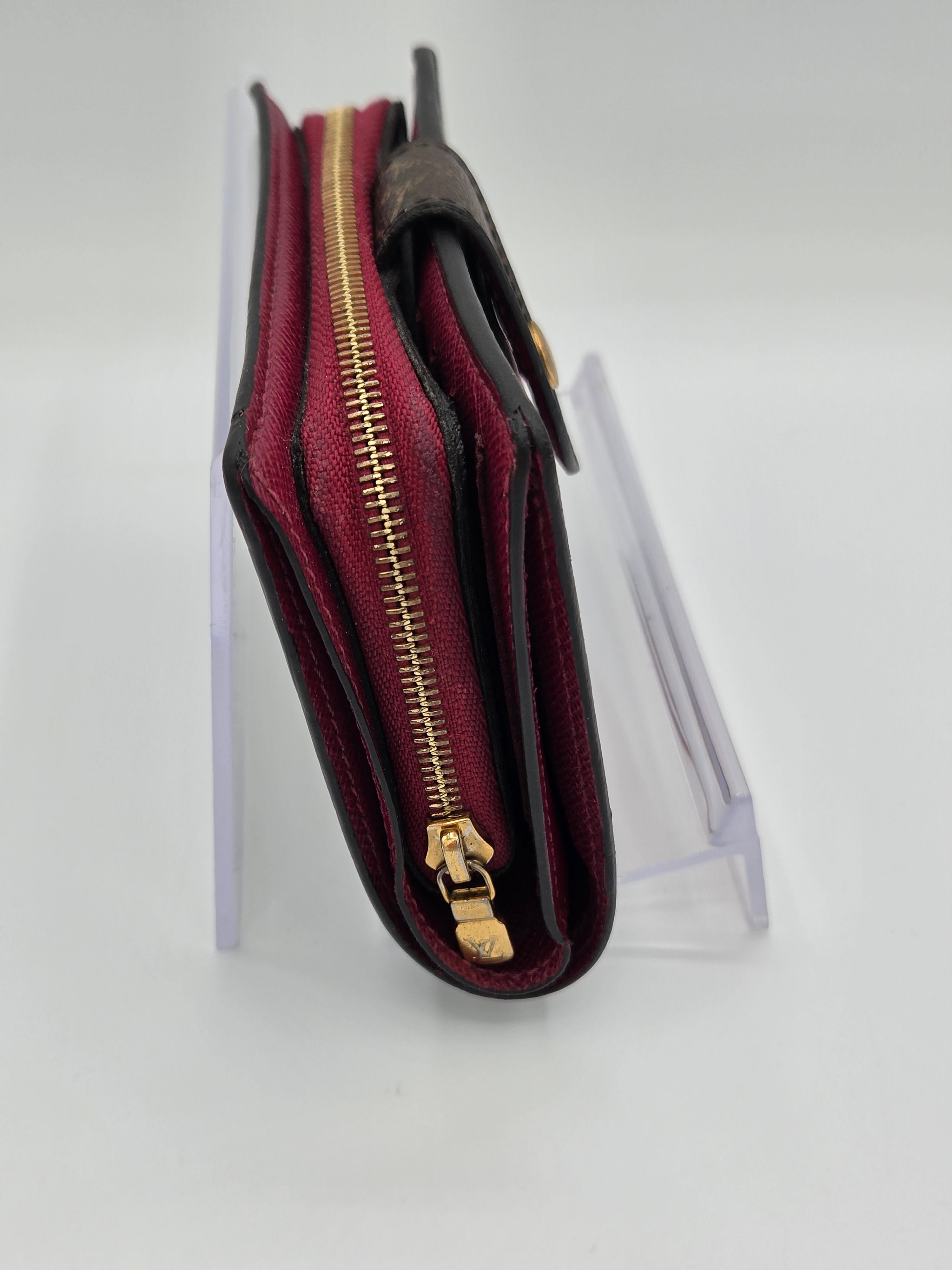 Red wallet with gold zipper on a white background