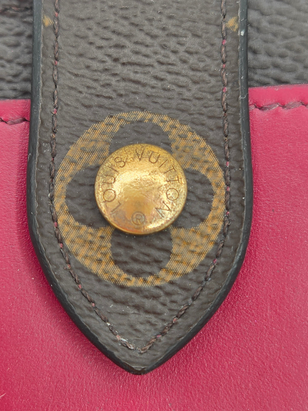 Close-up of a Louis Vuitton logo on a pink background