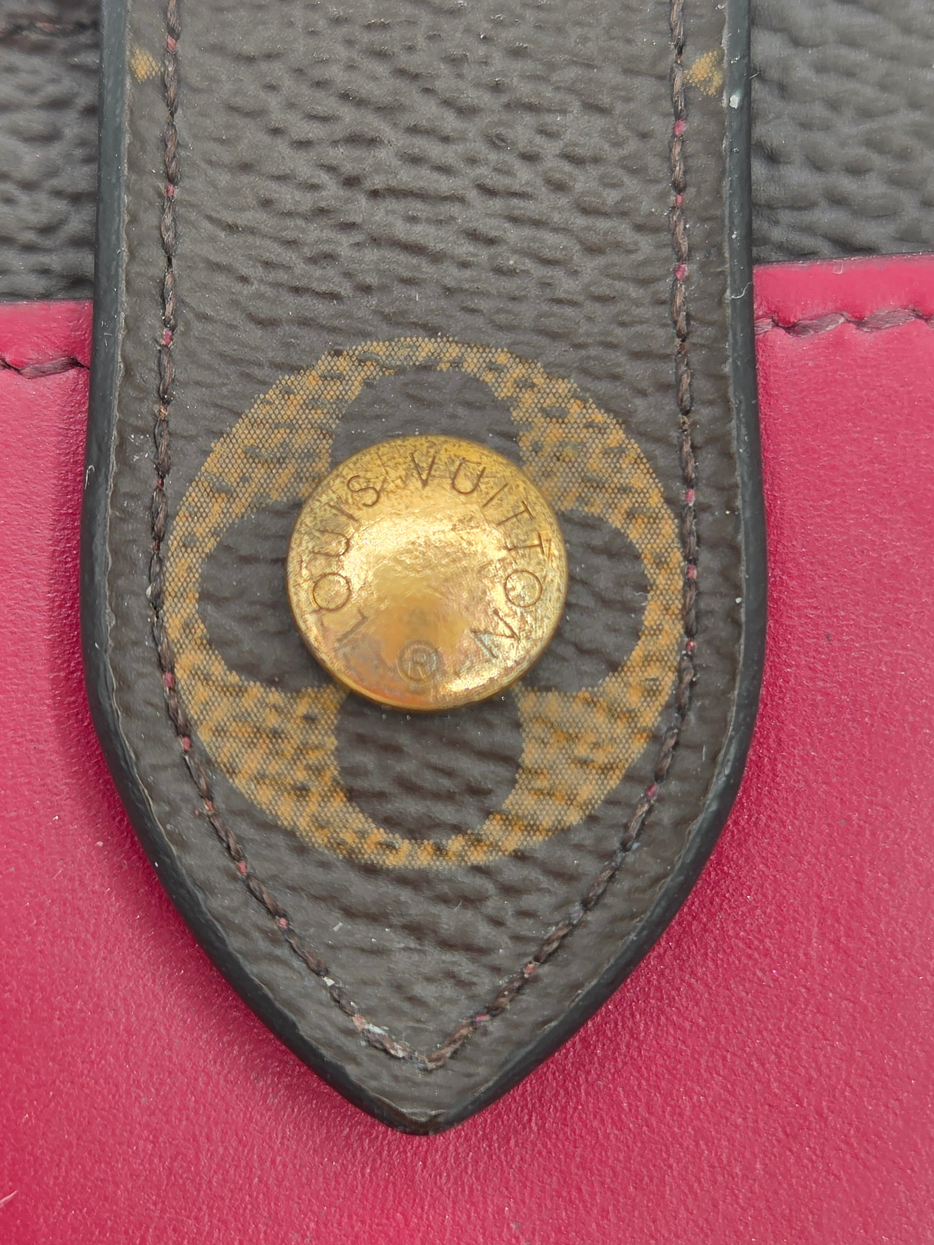 Close-up of a Louis Vuitton logo on a pink background