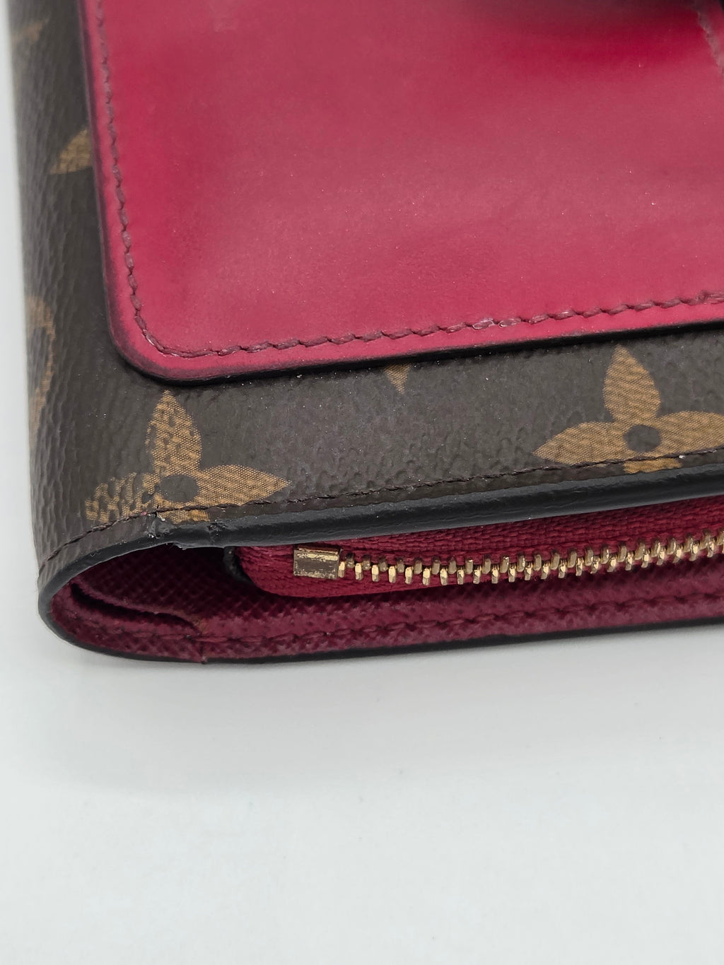 Close-up of a red wallet with a patterned flap on a white background