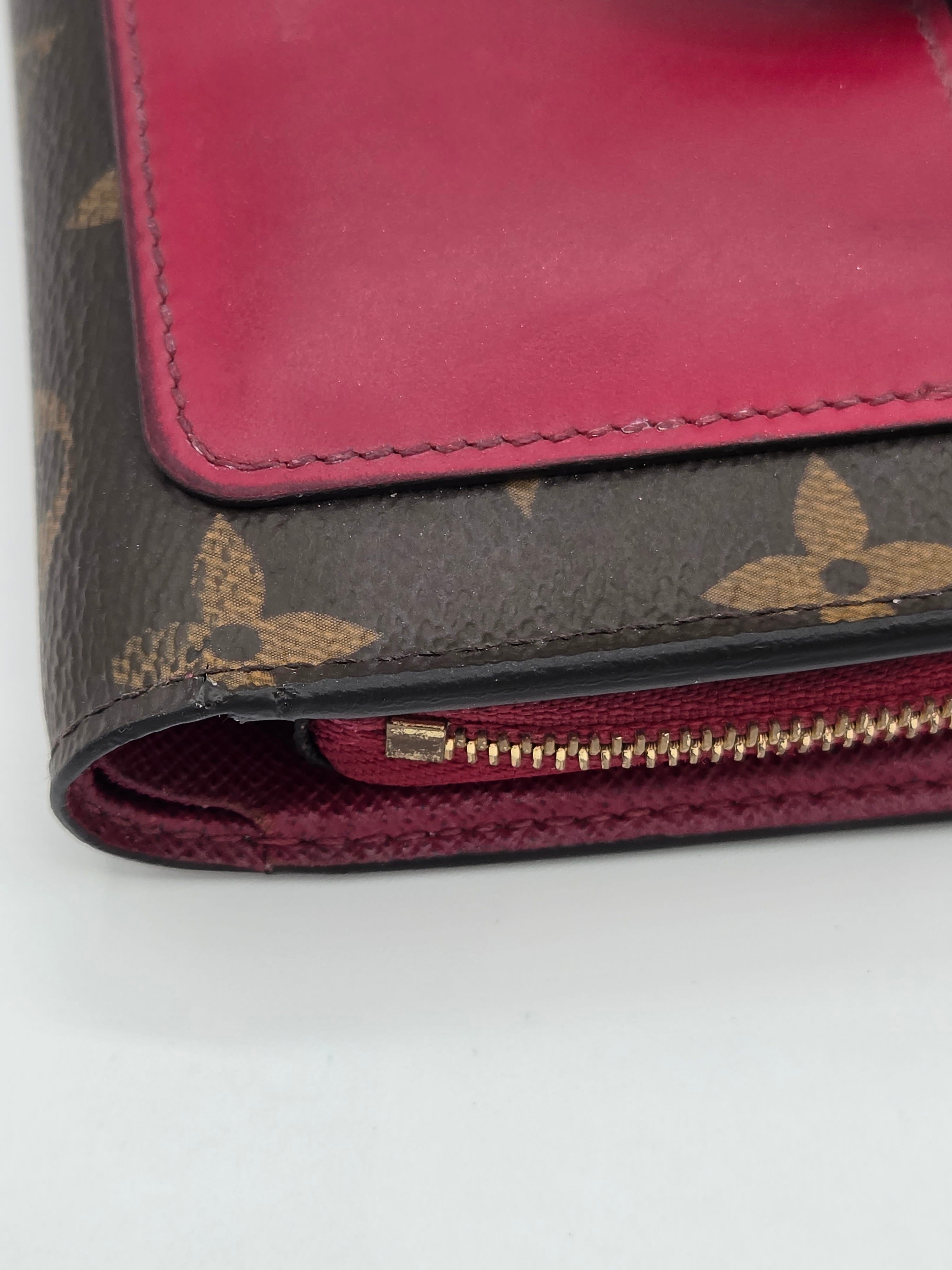 Close-up of a red wallet with a patterned flap on a white background