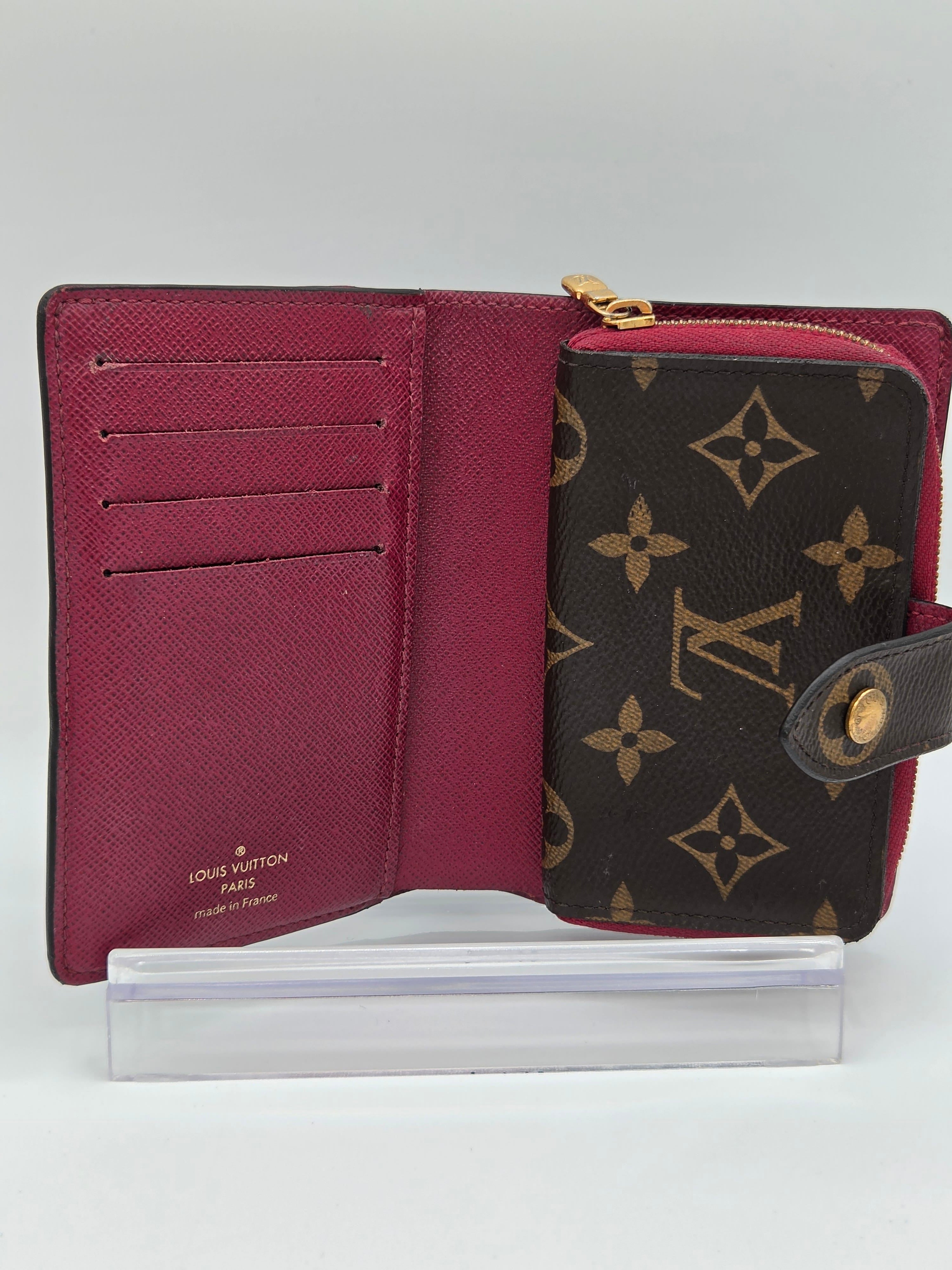 Louis Vuitton wallet with monogram pattern on a white background