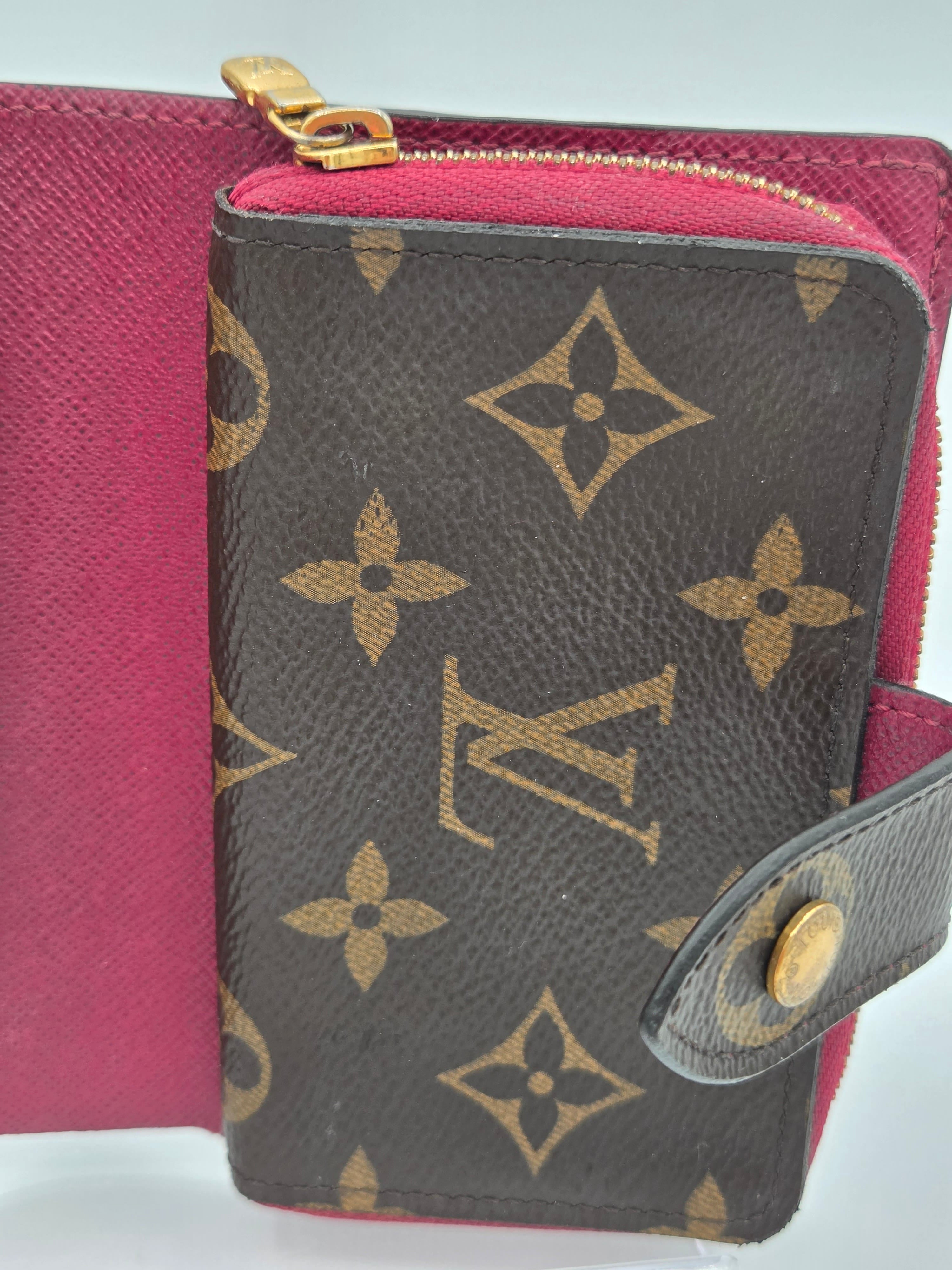 Louis Vuitton wallet with monogram pattern on a pink background