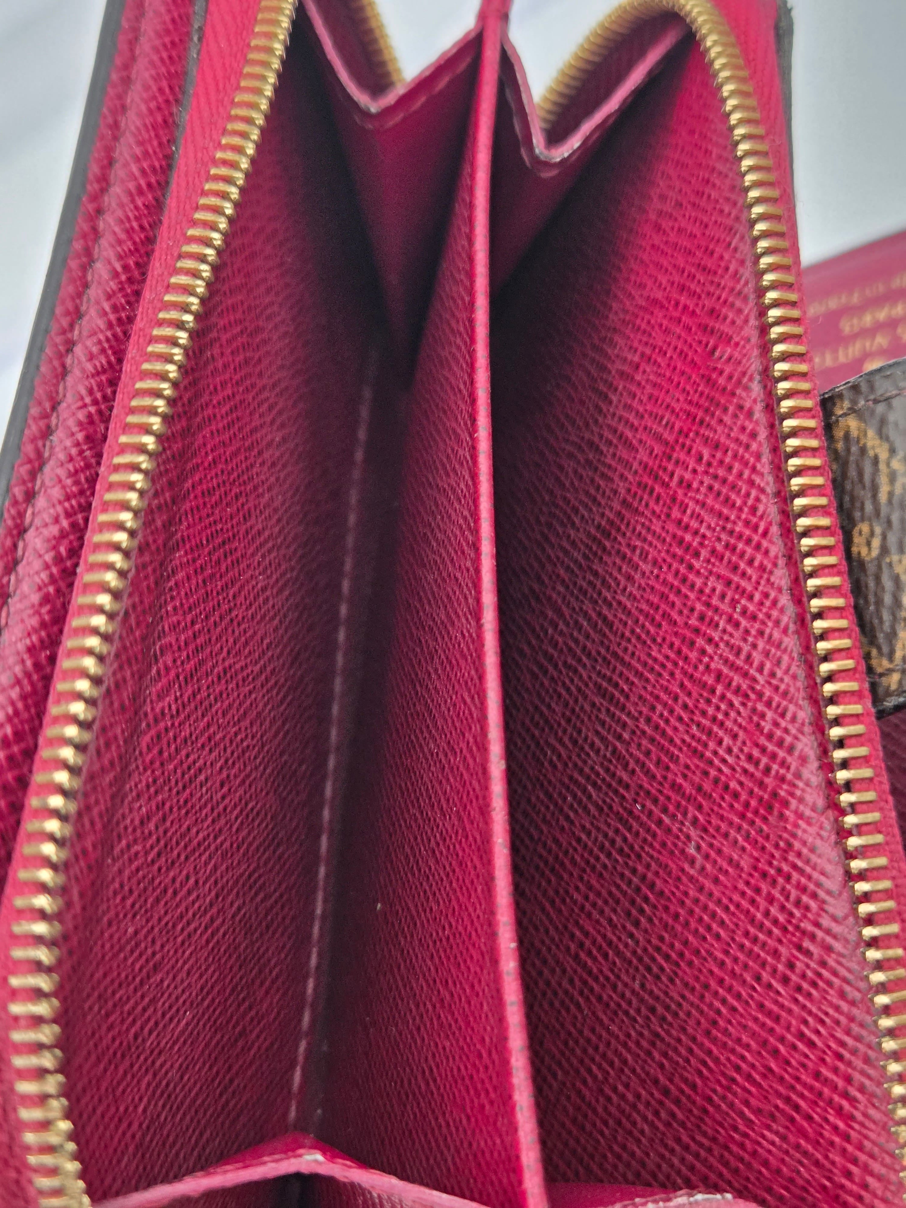 Close-up of a red wallet with gold zipper on a white background