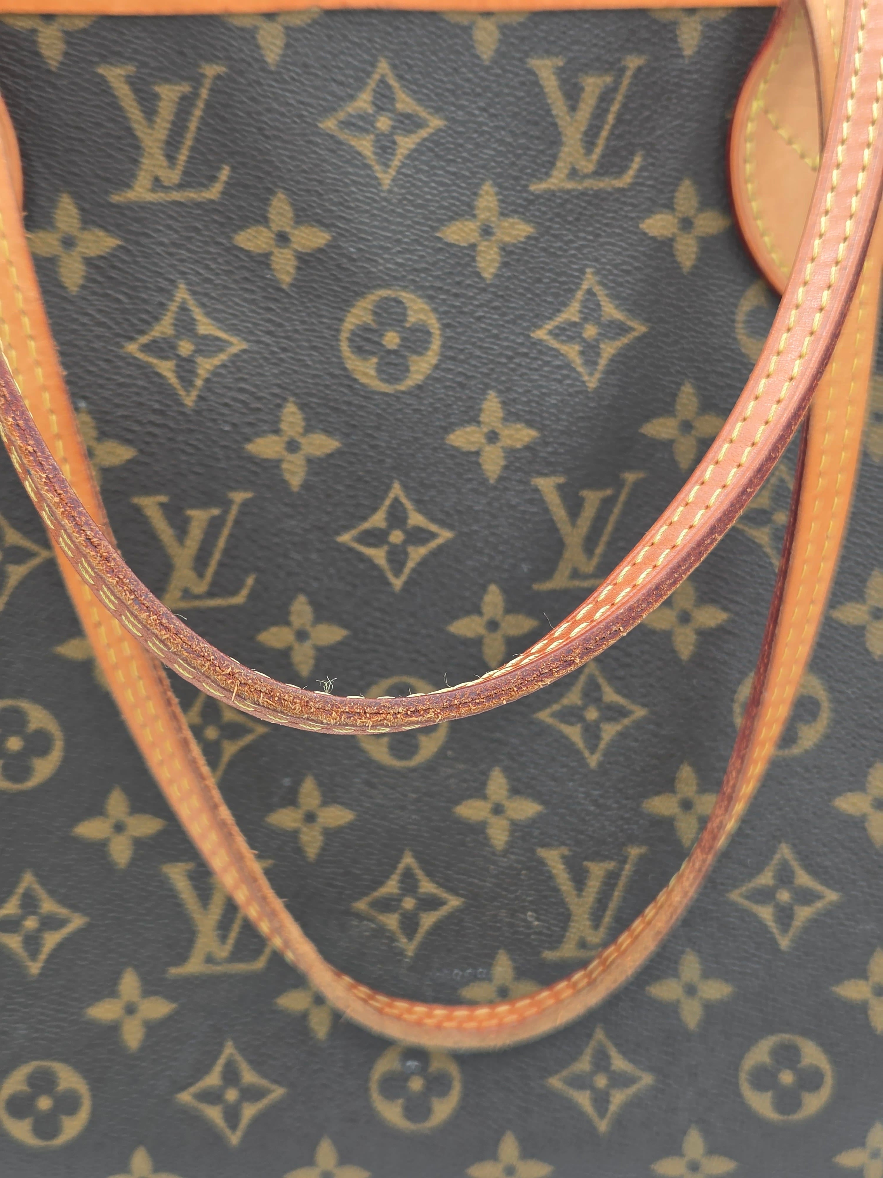 Close-up of a Louis Vuitton handbag with monogram pattern and brown leather handle.