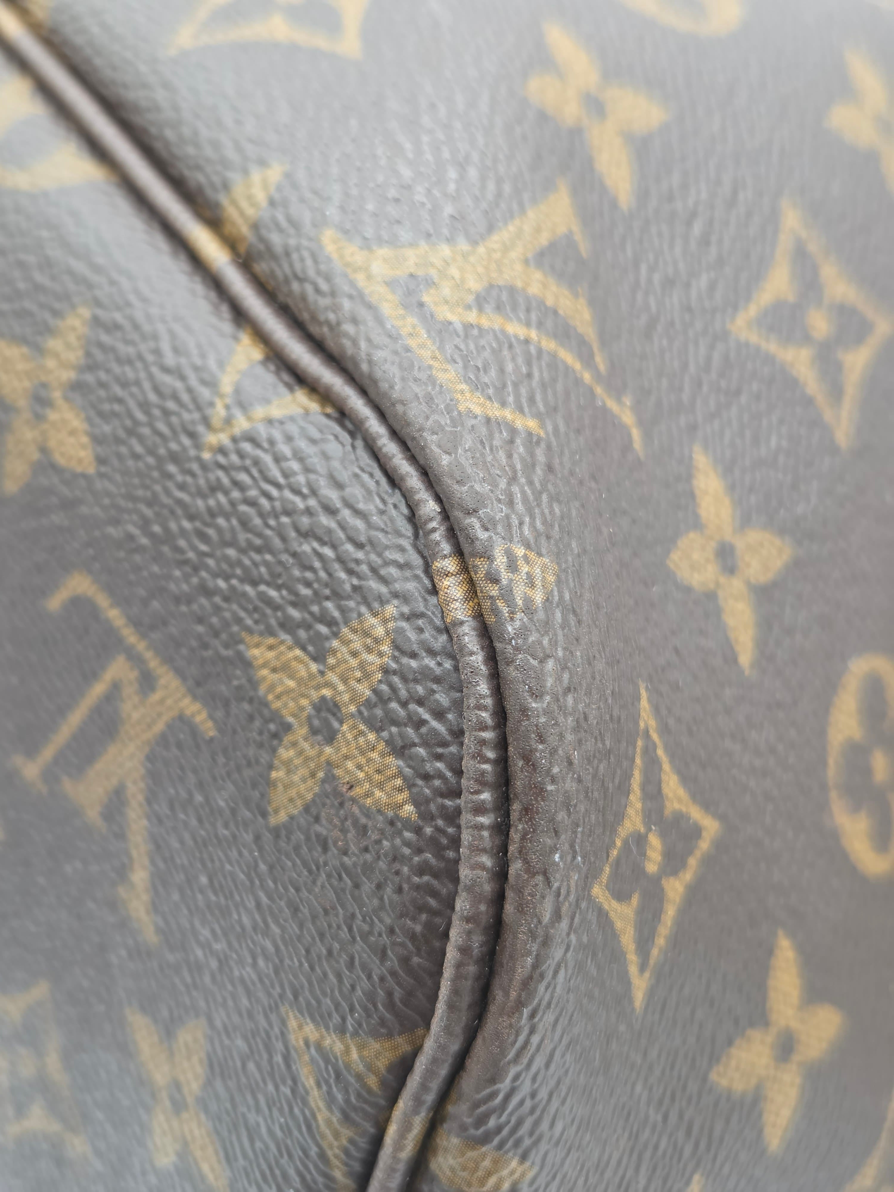 Close-up of a Louis Vuitton monogram bag with gold logo pattern.