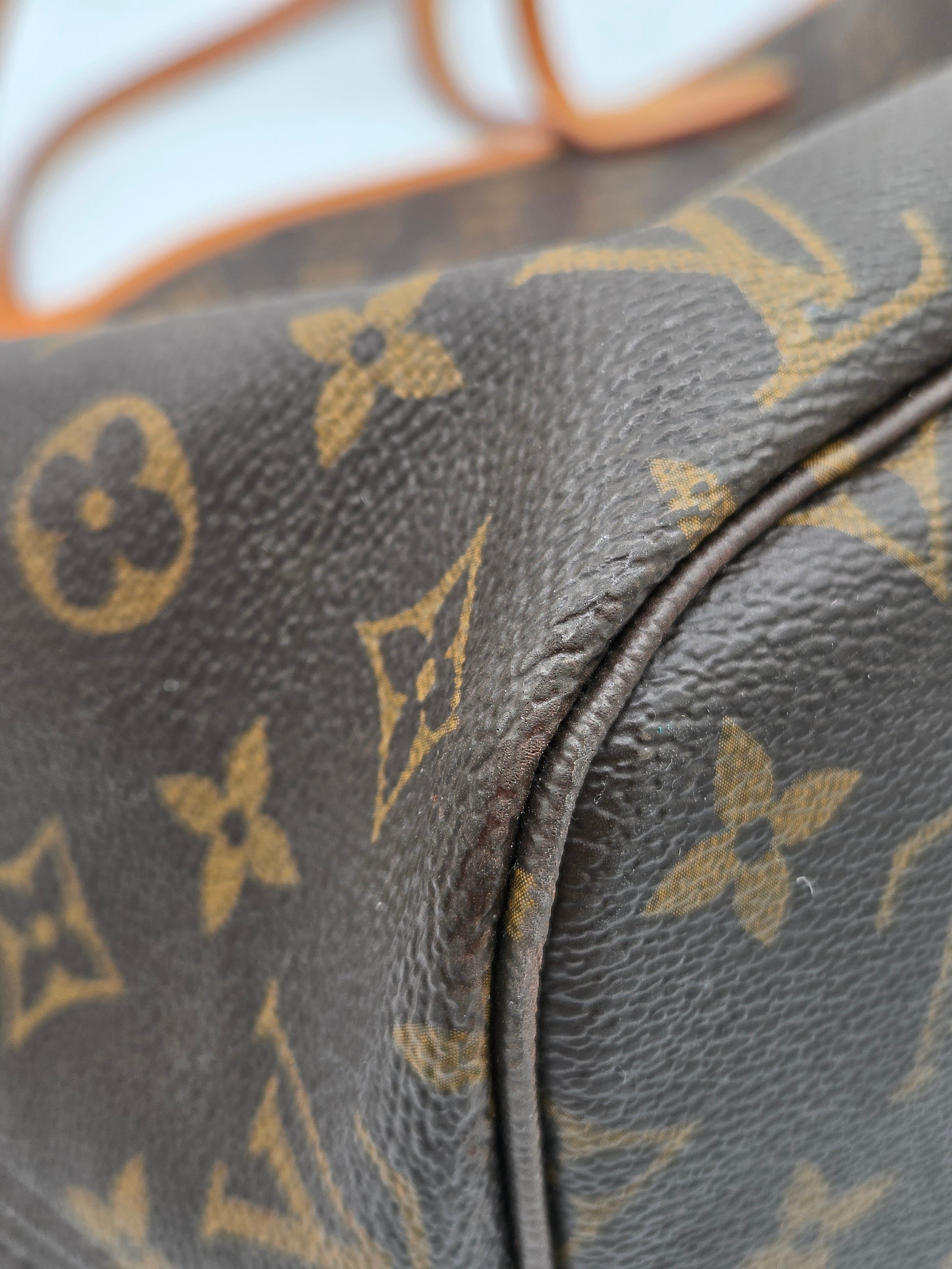 Close-up of a brown leather bag with gold monogram pattern