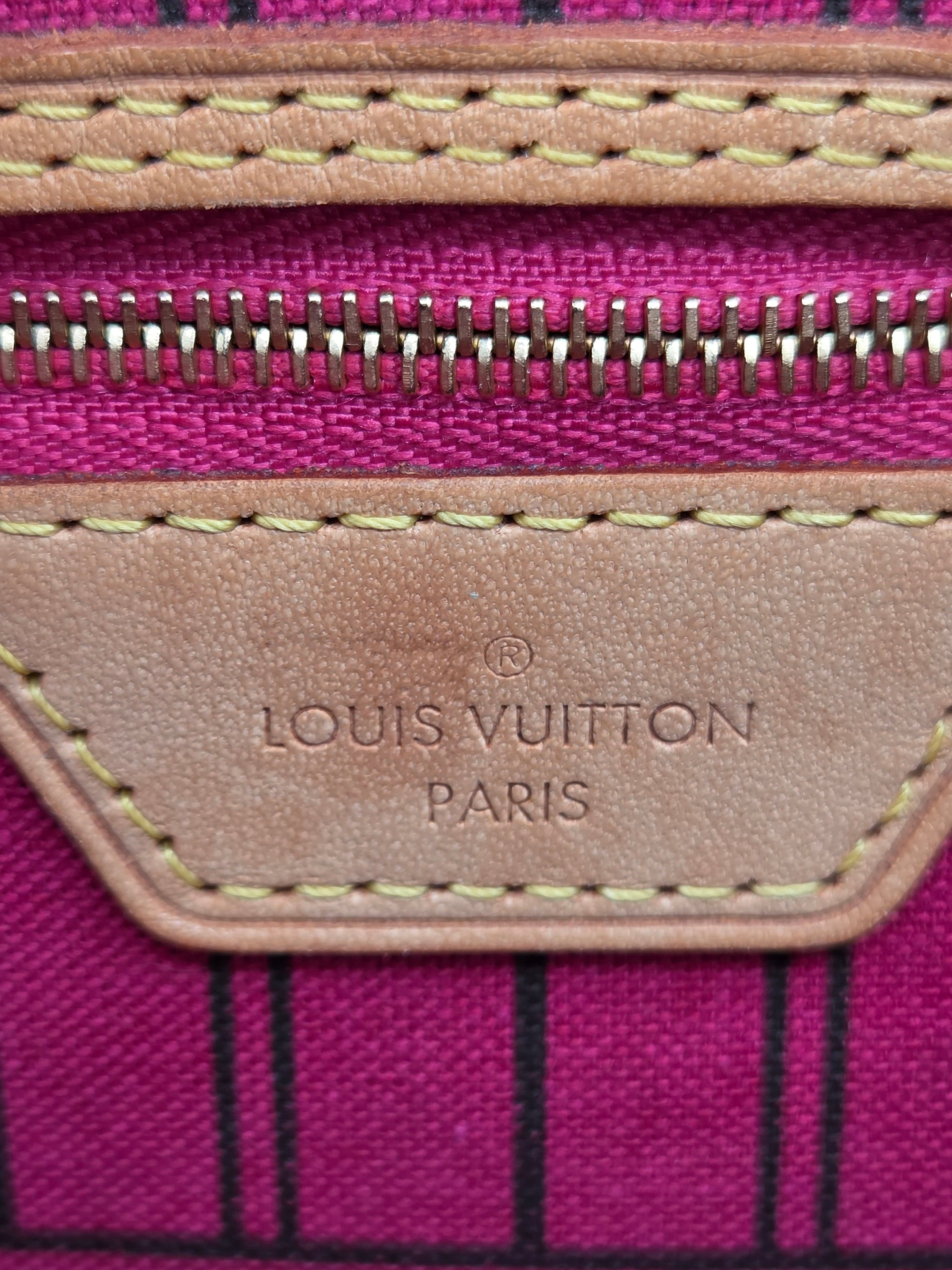 Close-up of a Louis Vuitton suitcase with pink and black striped pattern