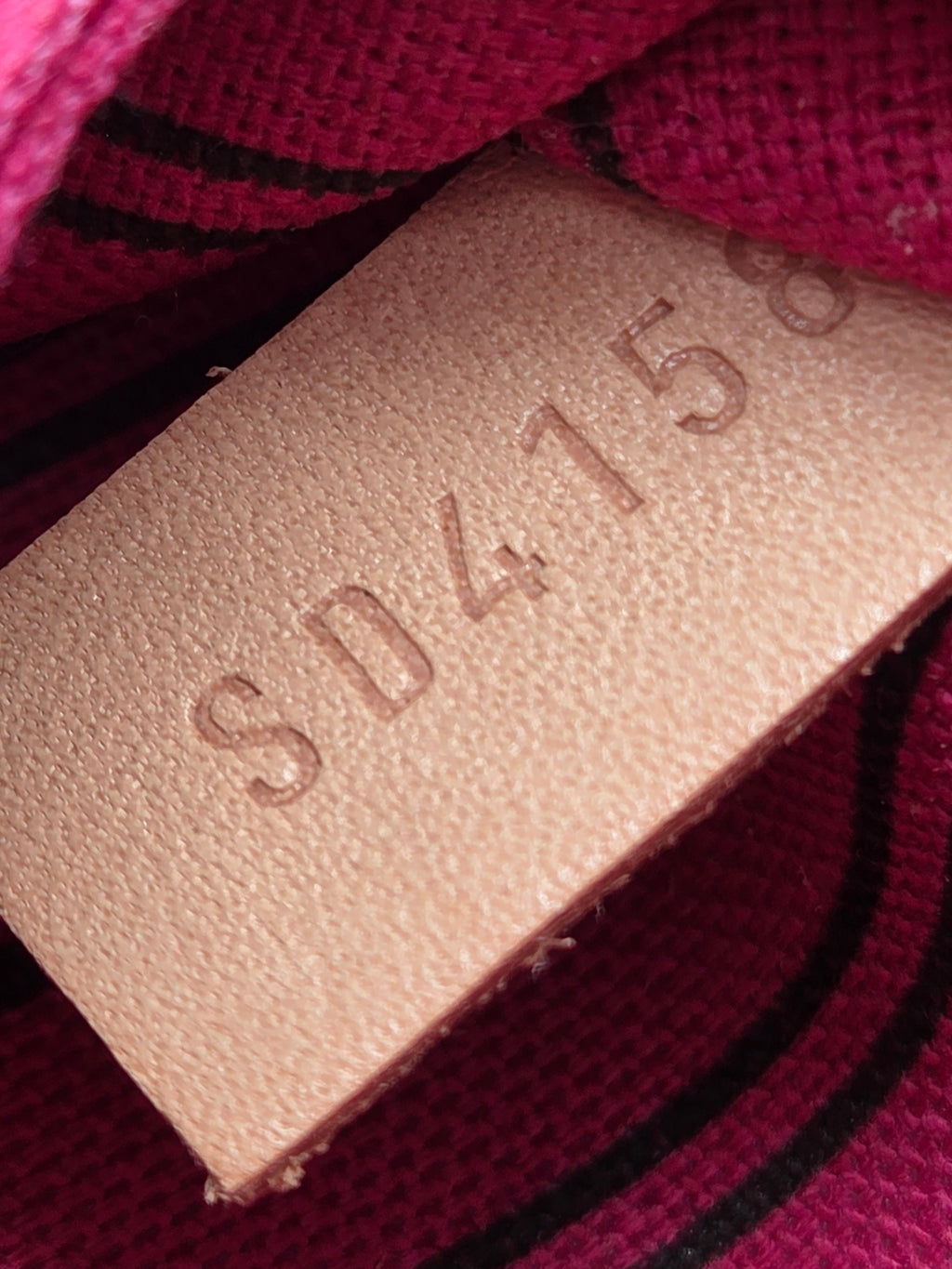 Close-up of a beige label with text on a red fabric background