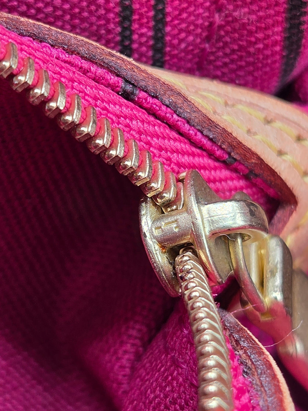 Close-up of a pink fabric with a gold zipper
