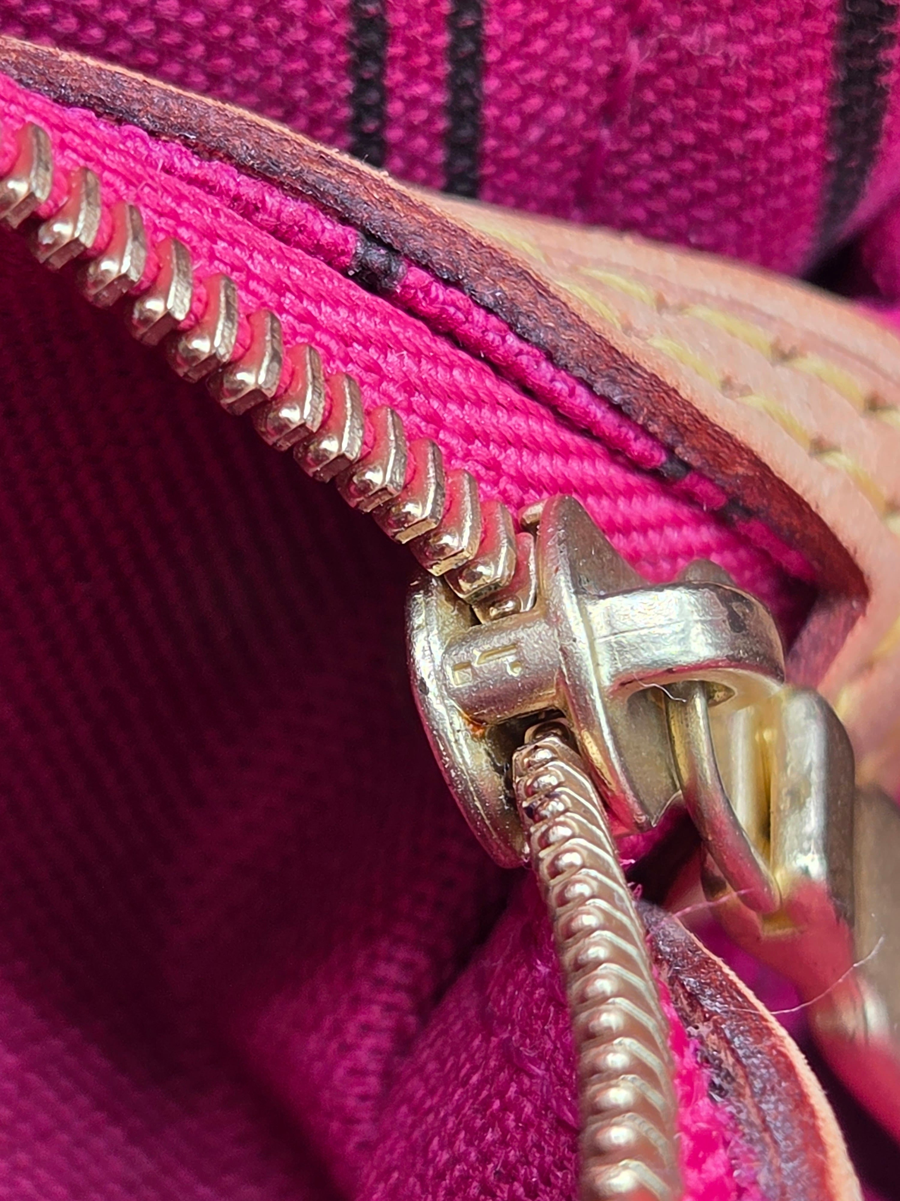 Close-up of a pink fabric with a gold zipper
