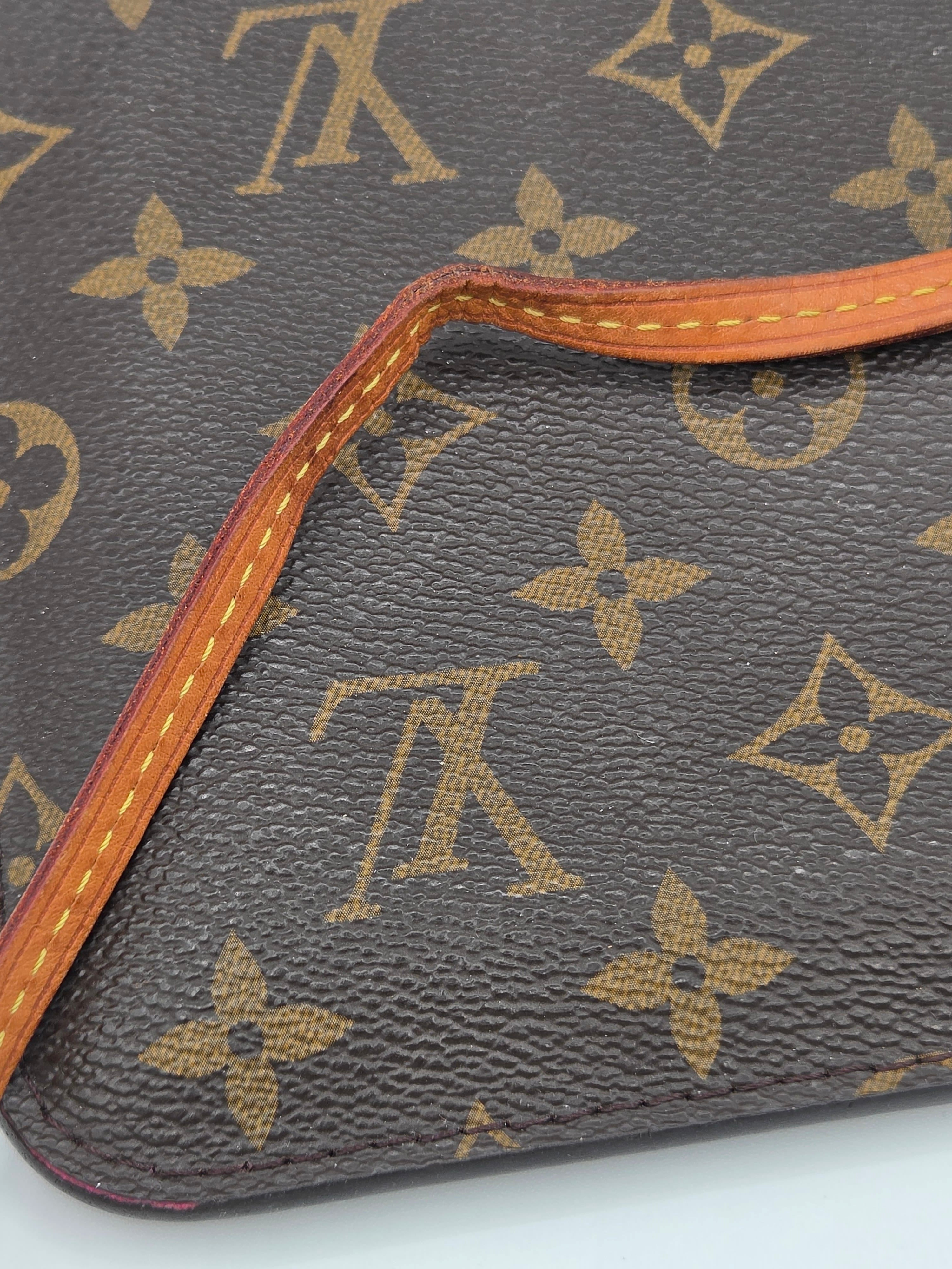 Close-up of a Louis Vuitton monogram handbag with brown leather trim.