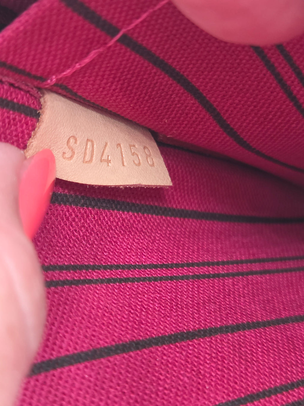 Close-up of a fabric tag with a number on a red and black striped background