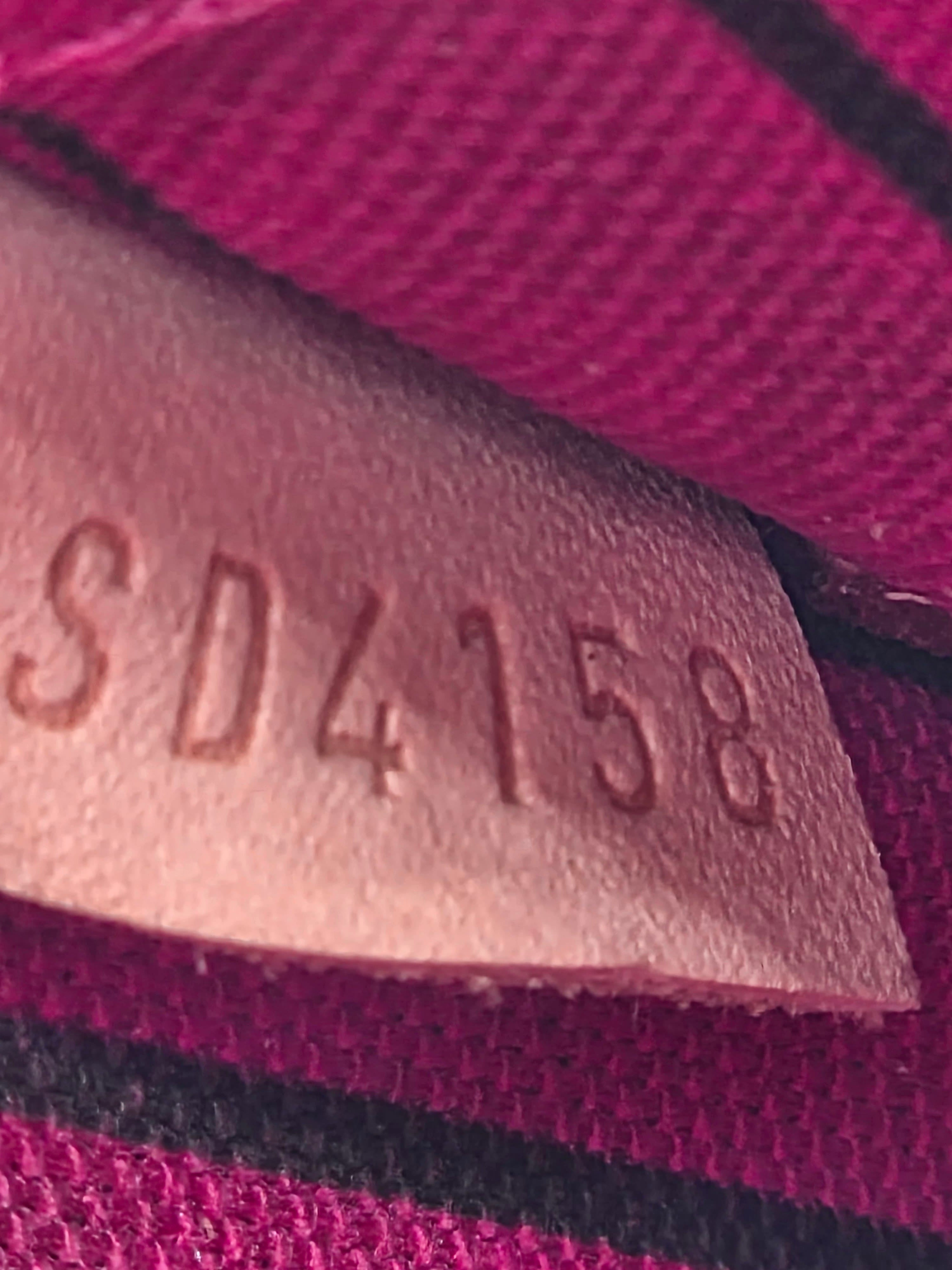 Close-up of a textured label with 'SD4158' on a pink fabric background