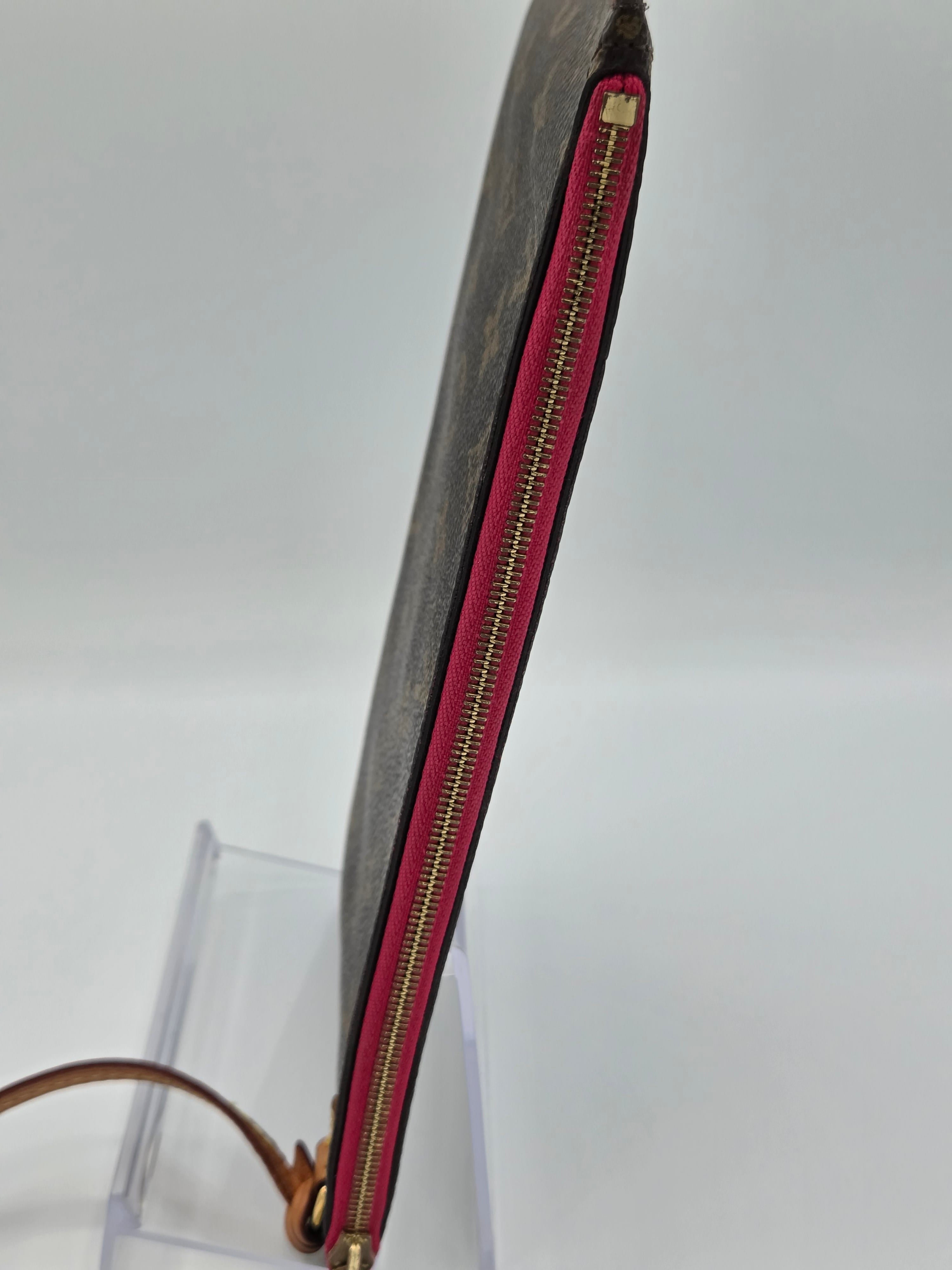 Long rectangular pouch with red zipper on a clear stand against a white background