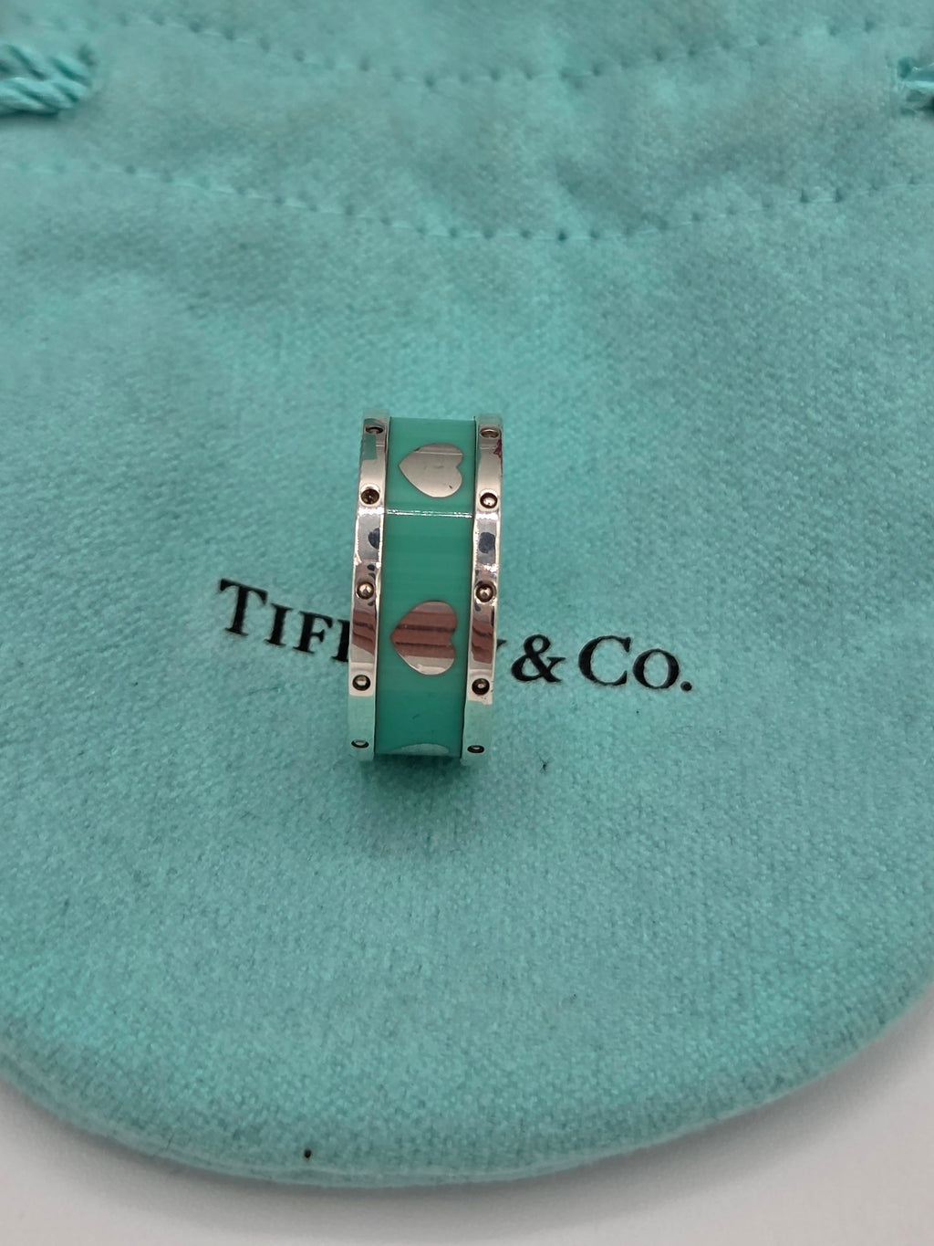 Tiffany & Co. bracelet with heart charms on a teal cushion