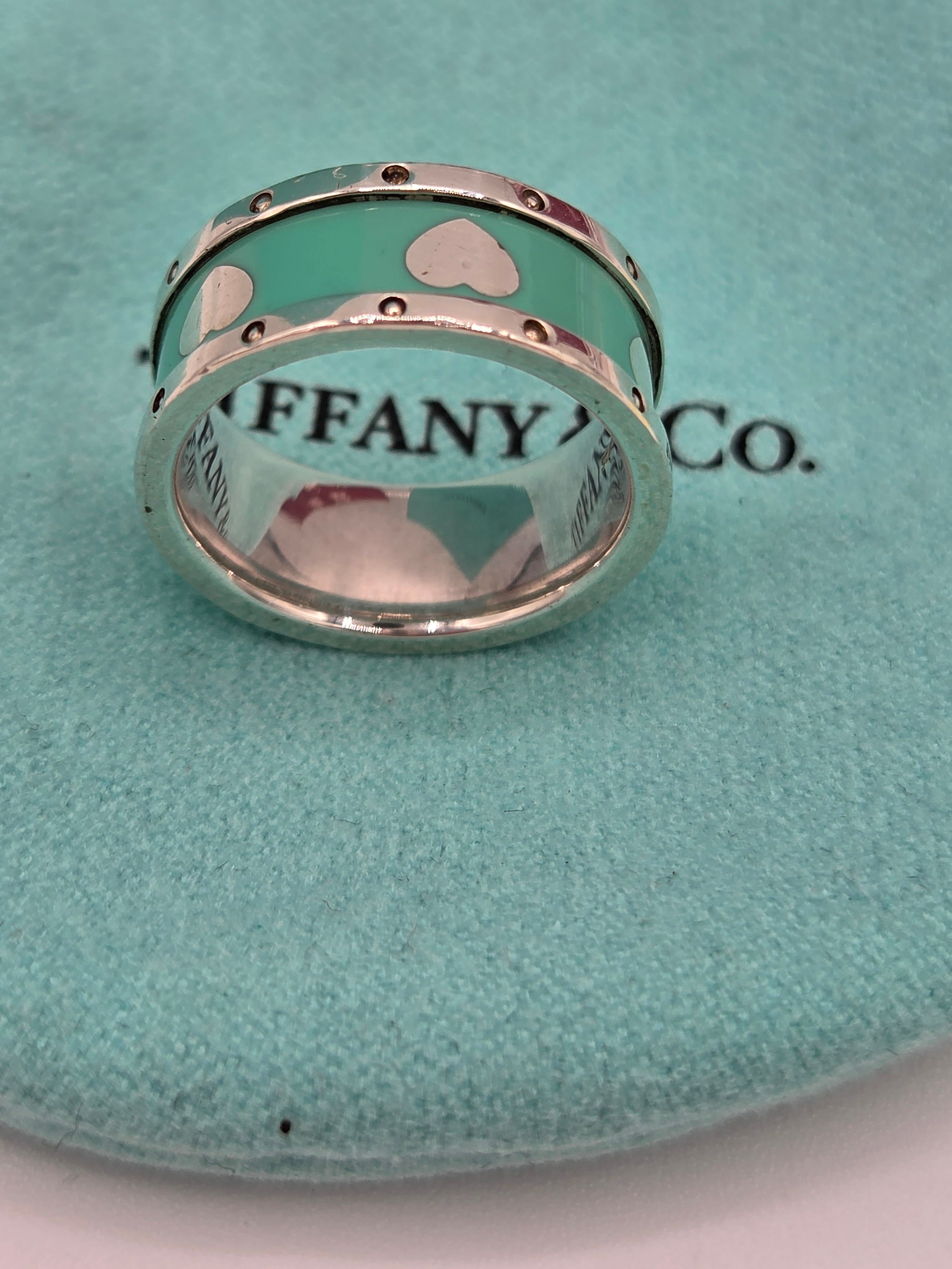 Two Tiffany & Co. rings on a green cushion with the brand's logo.