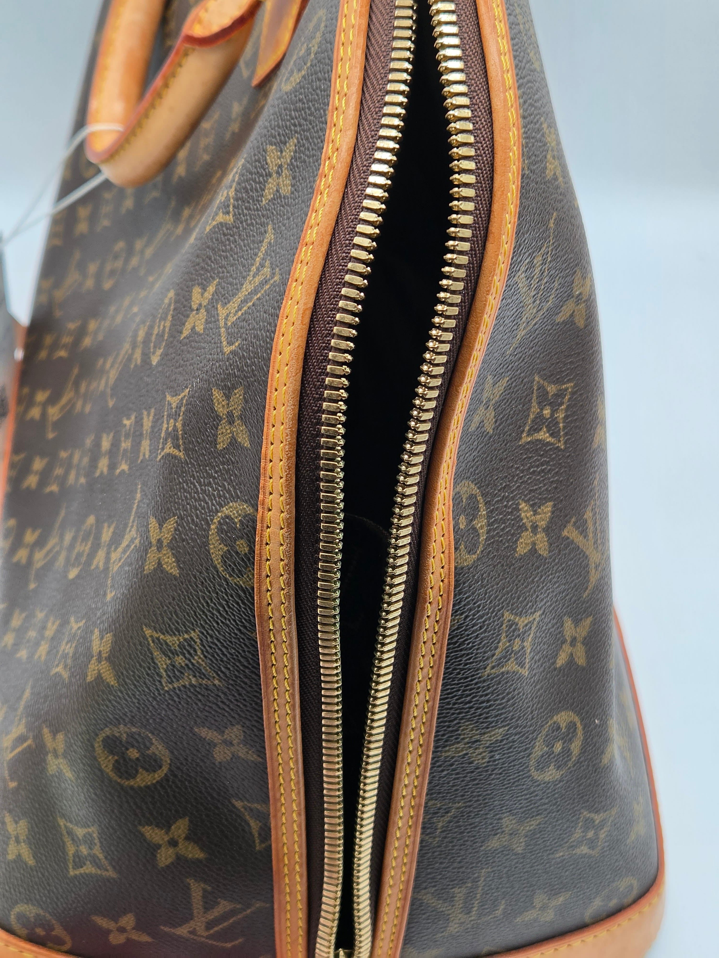 Close-up of a Louis Vuitton monogram handbag with a clear plastic cover.