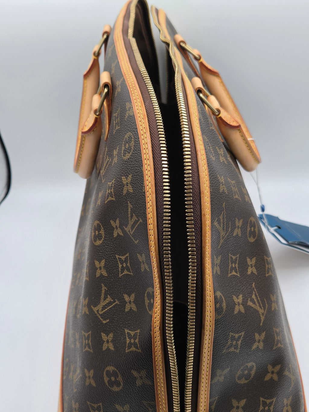Designer handbag with monogram pattern on a light gray background