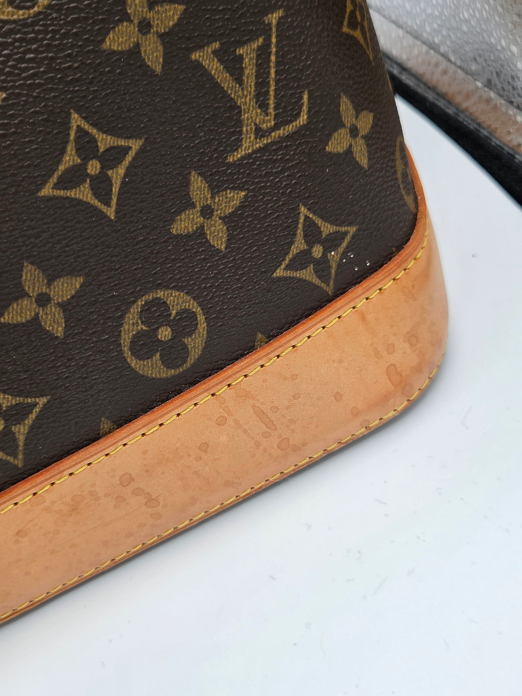 Louis Vuitton wallet with monogram pattern on a white background