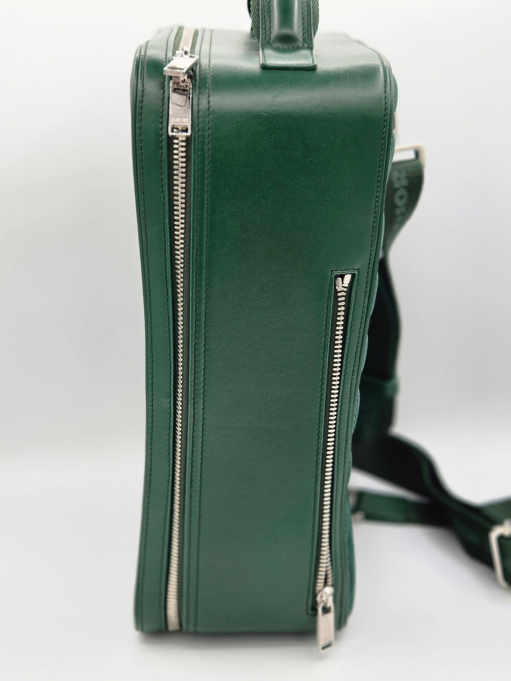 Green leather bag with zippers on a white background