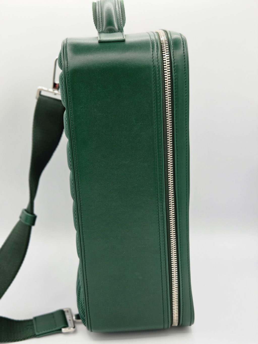 Green handbag with a strap on a light gray background