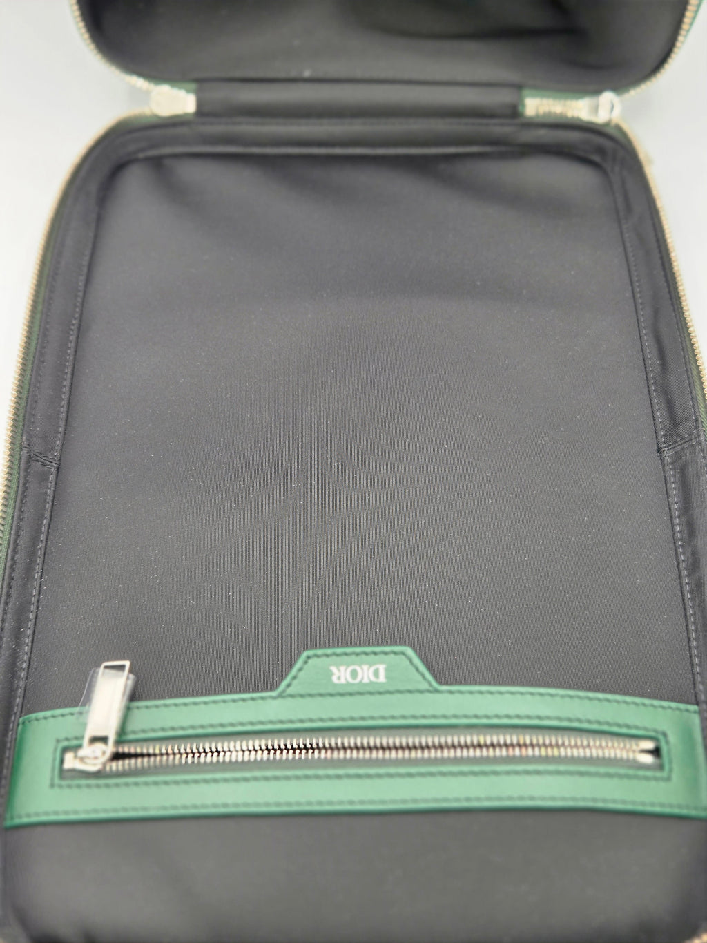 Gray bag with green zipper and visible brand logo on a white background