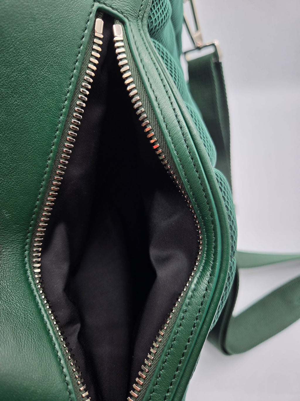 Green leather bag with a zipper on a light gray background