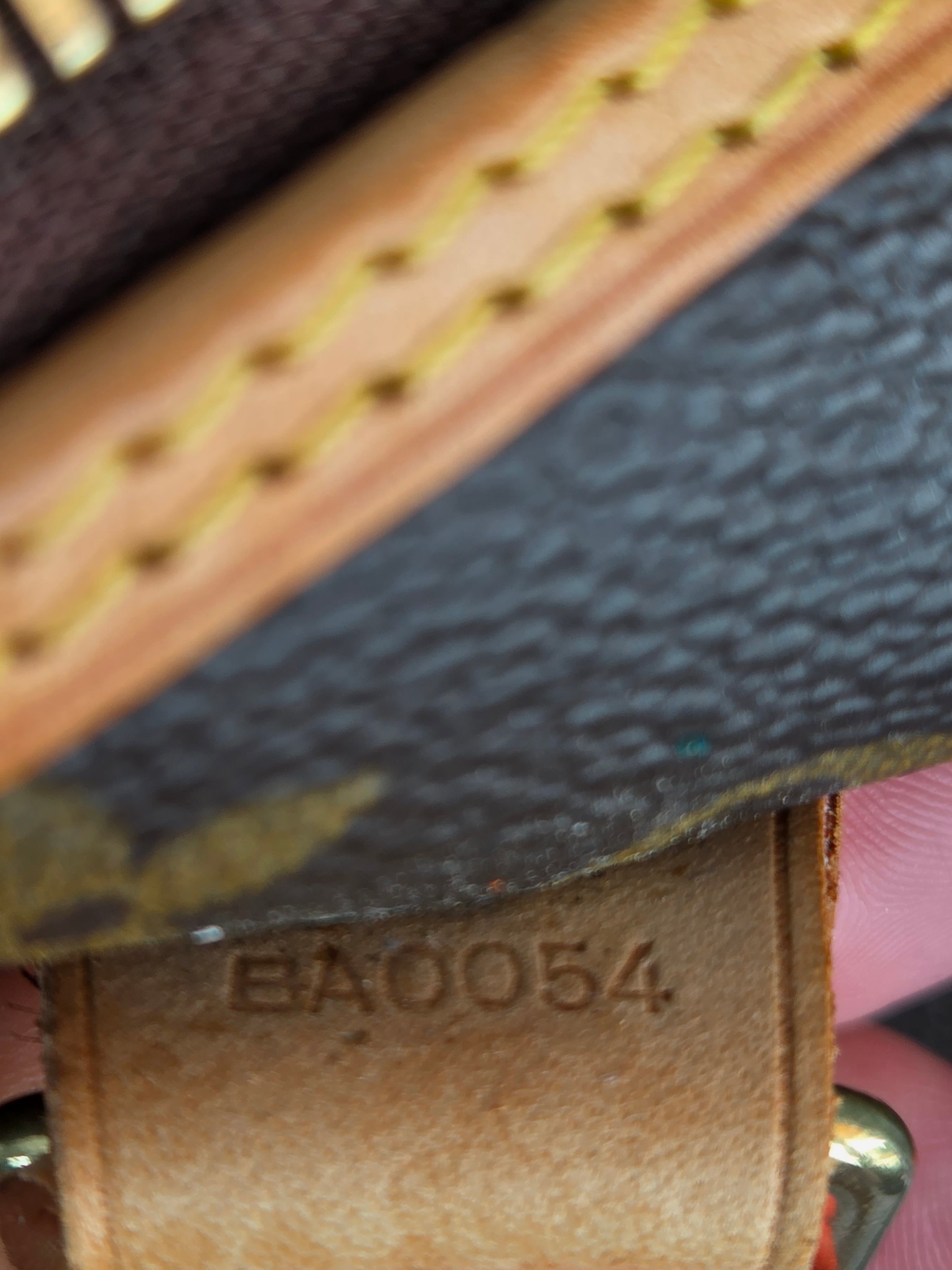 Close-up of a leather product with visible branding and stitching details.