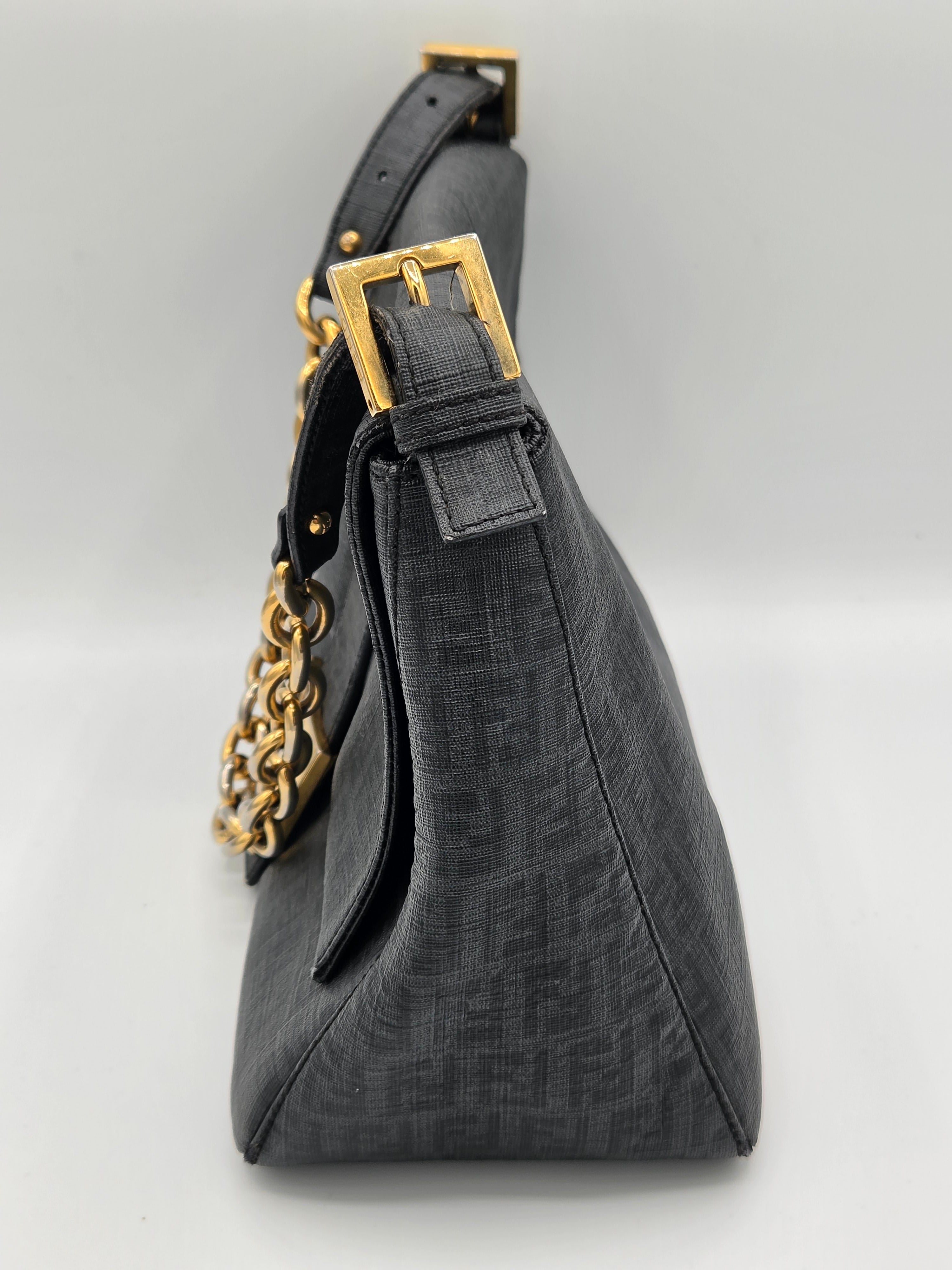 Black bag with gold chain and buckle on a light gray background
