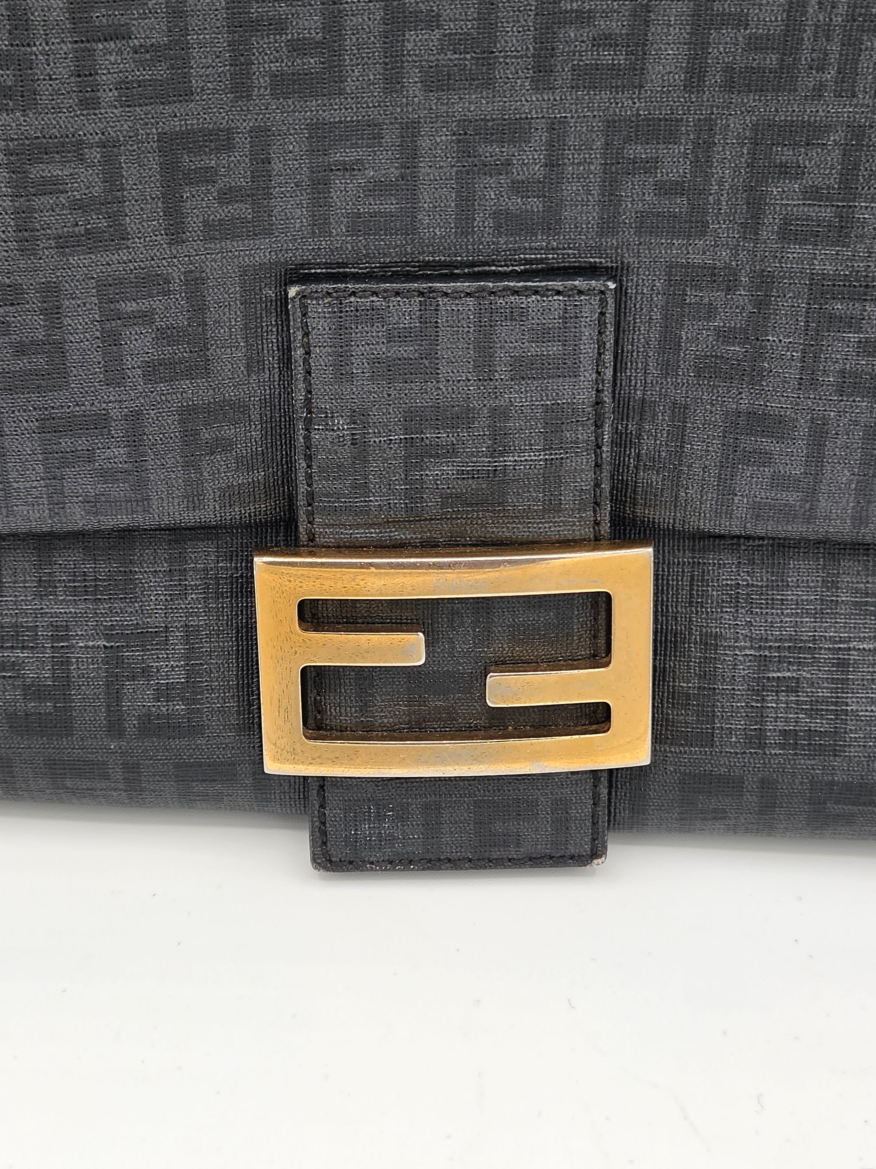 Black textured bag with gold logo buckle on a white background