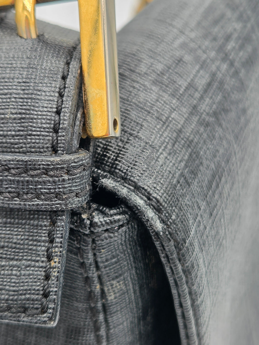 Close-up of a gray fabric with a gold zipper, possibly on a bag or garment.