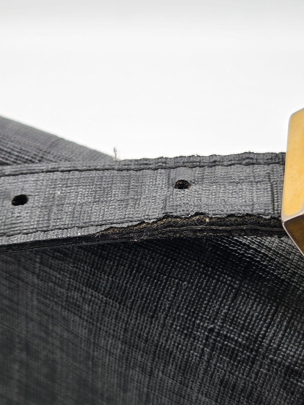 Close-up of a textured gray fabric with a wooden stick on a white background