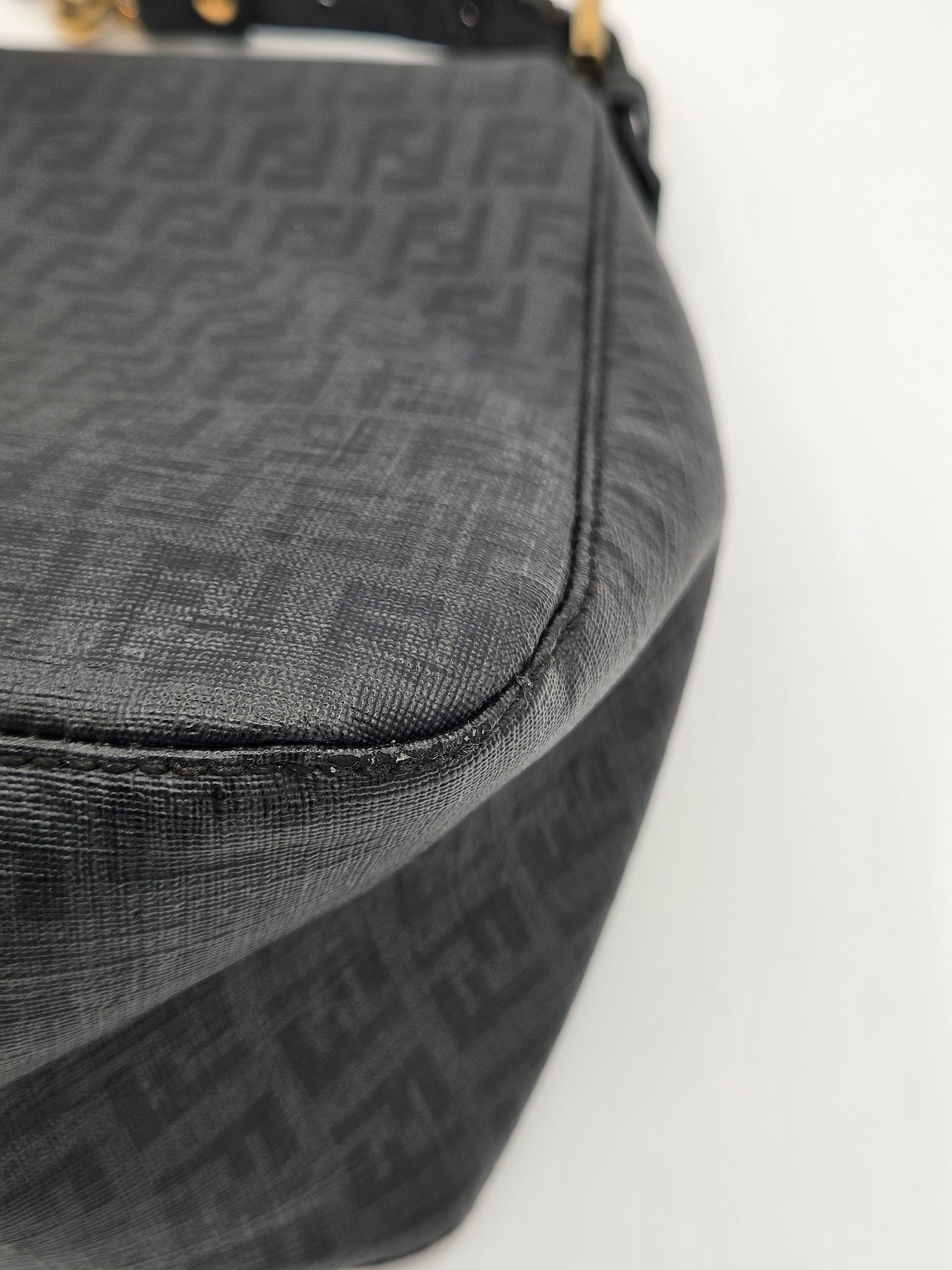 Close-up of a black textured bag with a brand logo on a light gray background