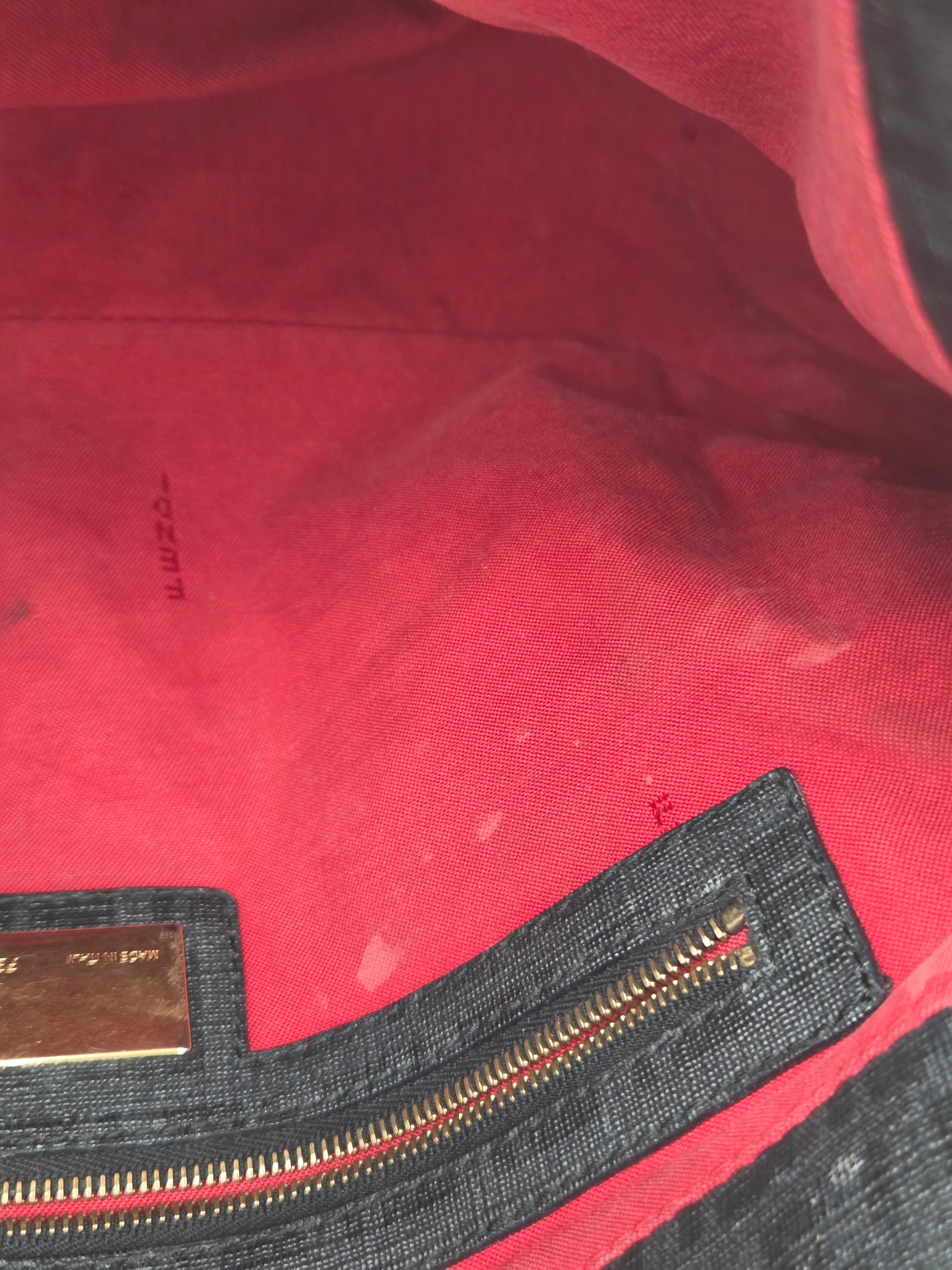Close-up of a red garment with a zipper and visible brand label.