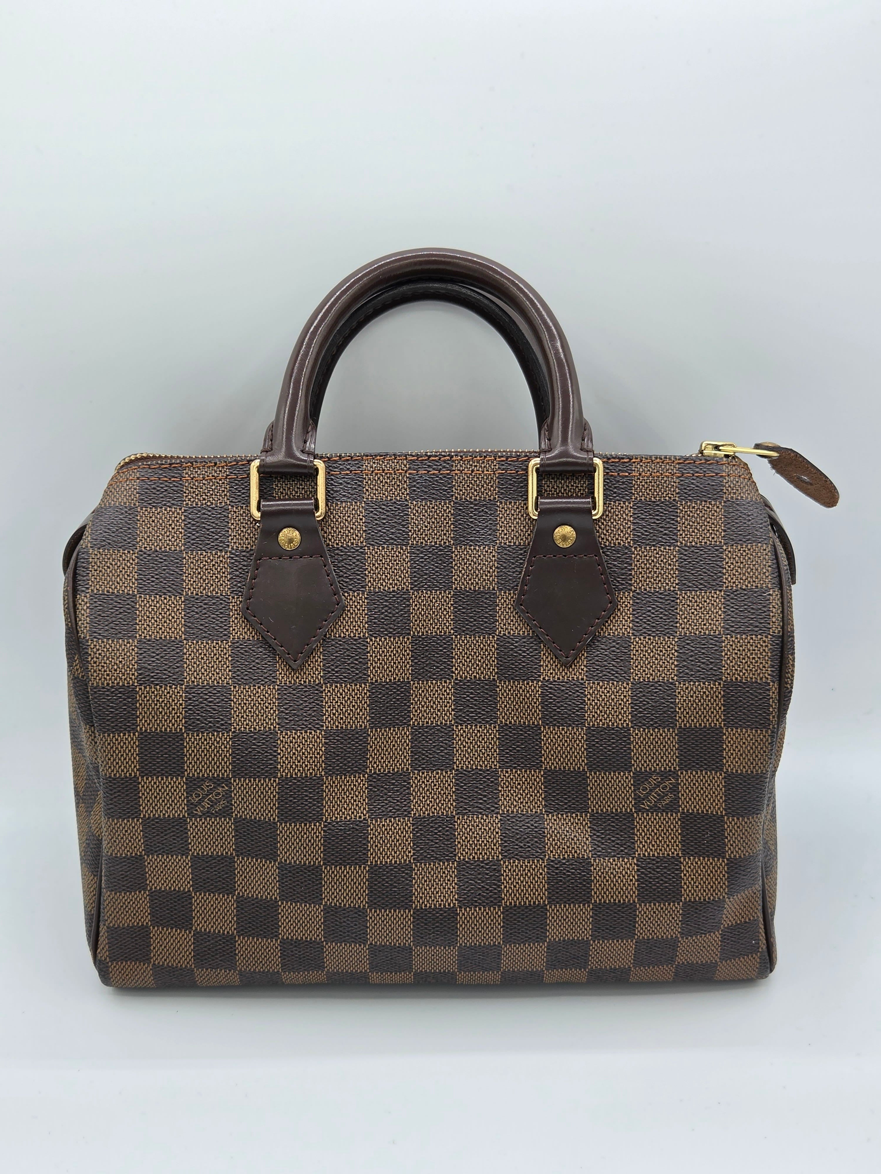 Brown checkered handbag with gold accents on a white background