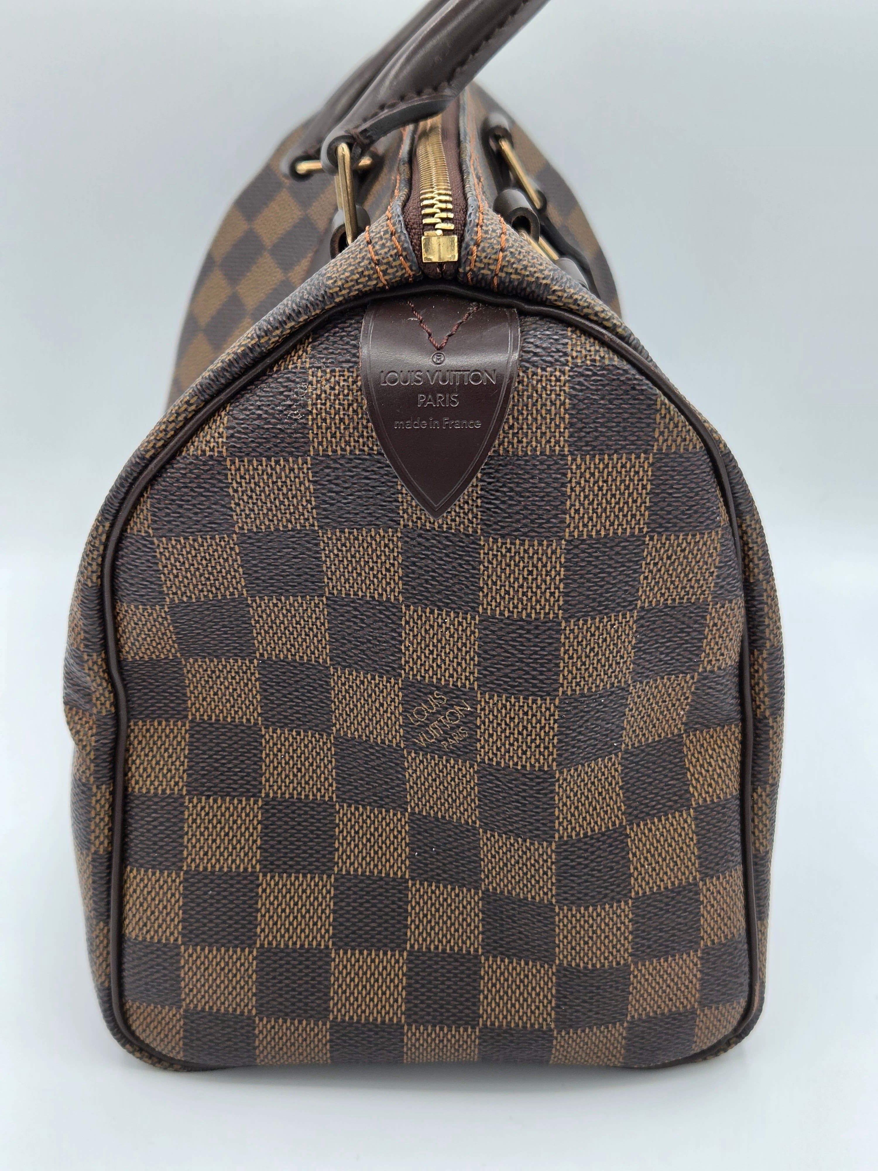 Brown checkered handbag with visible brand logo on a light gray background