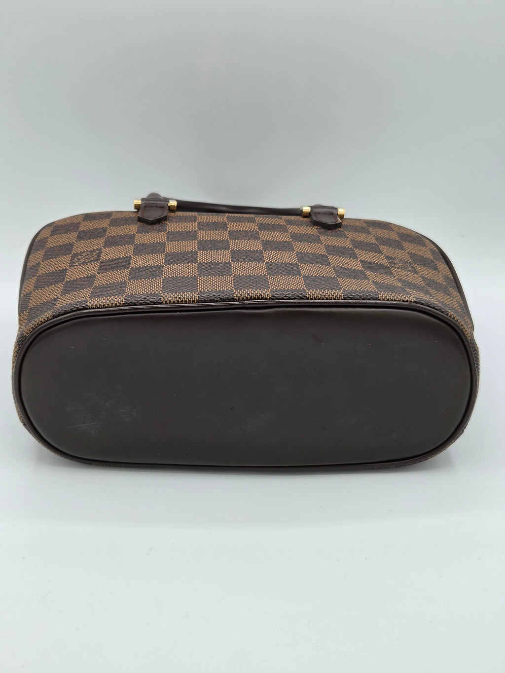 Designer handbag with checkered pattern on a light gray background