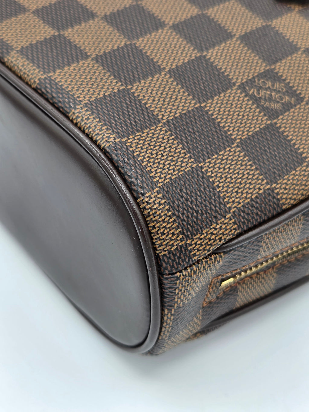 Louis Vuitton bag with checkered pattern on a light gray background